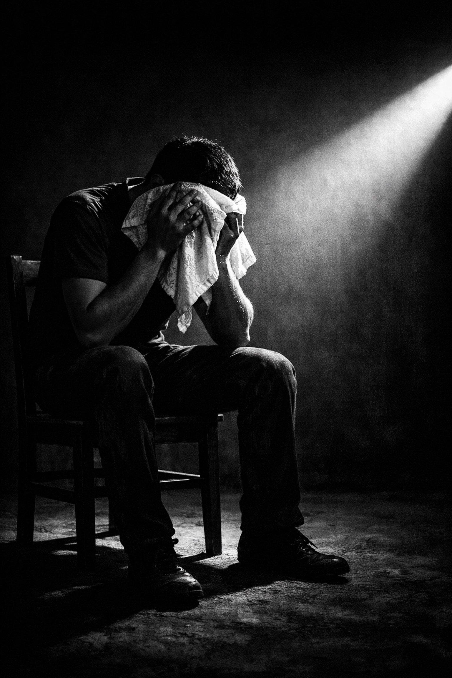 A man shields his face from a spotlight, representing the Queen Boat trial and the struggle for privacy.