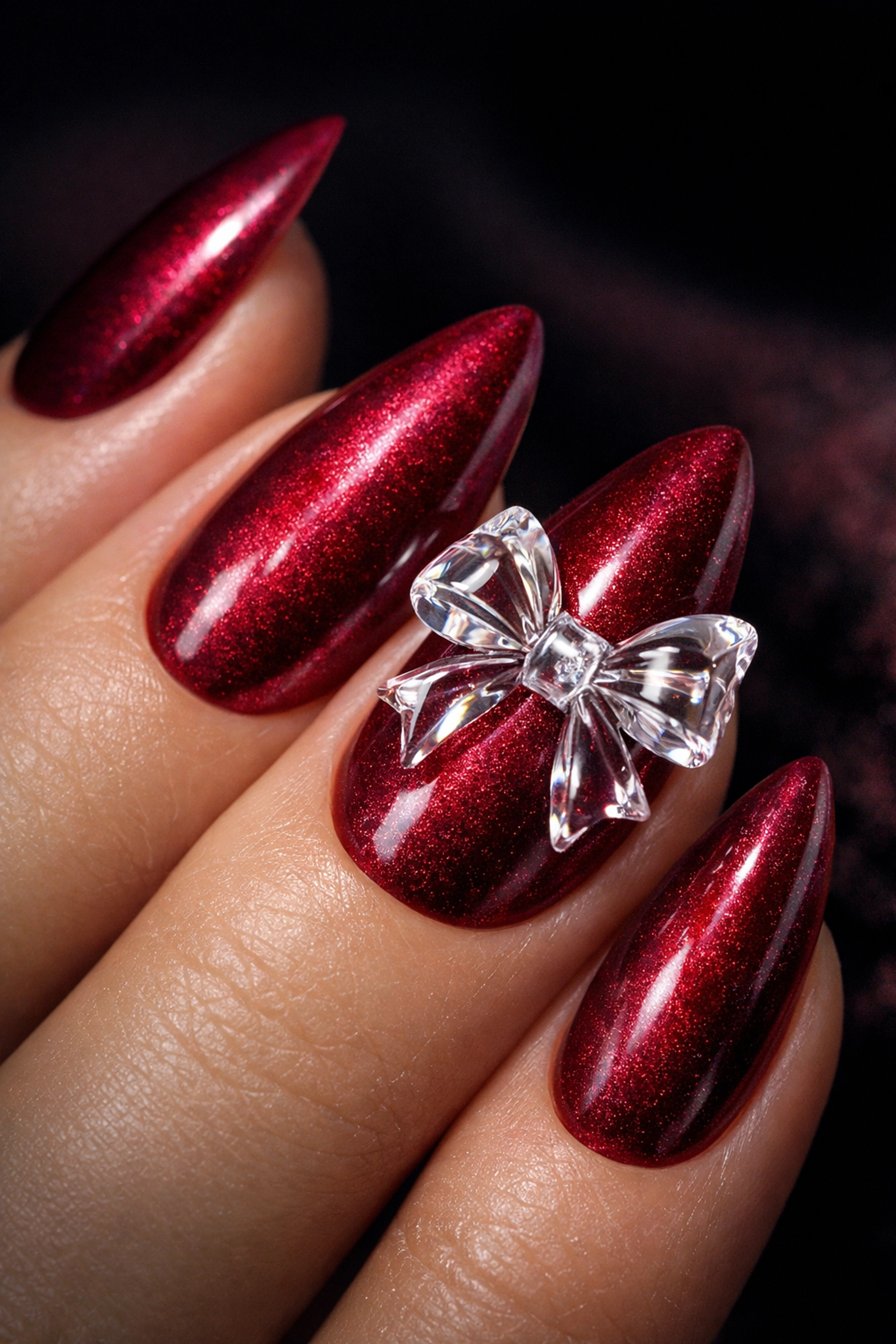 Almond-shaped 3D velvet nails in raspberry red with a sculpted magnetic gel bow.