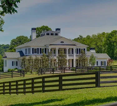 Elegant Southern estate with classic white columns and wrap-around porches representing Brentwood luxury