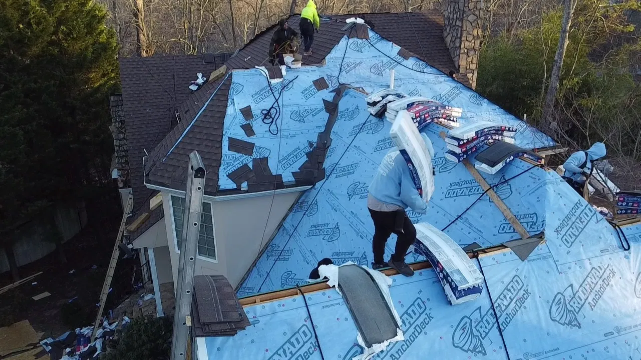 Professional roofing crew installing new shingles with high-quality underlayment