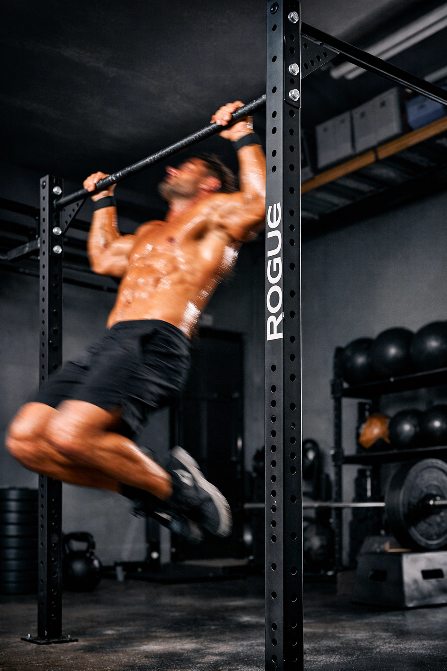 Crossfit athlete doing kipping pull-ups on a stable, no wall damage floor to ceiling gym system.