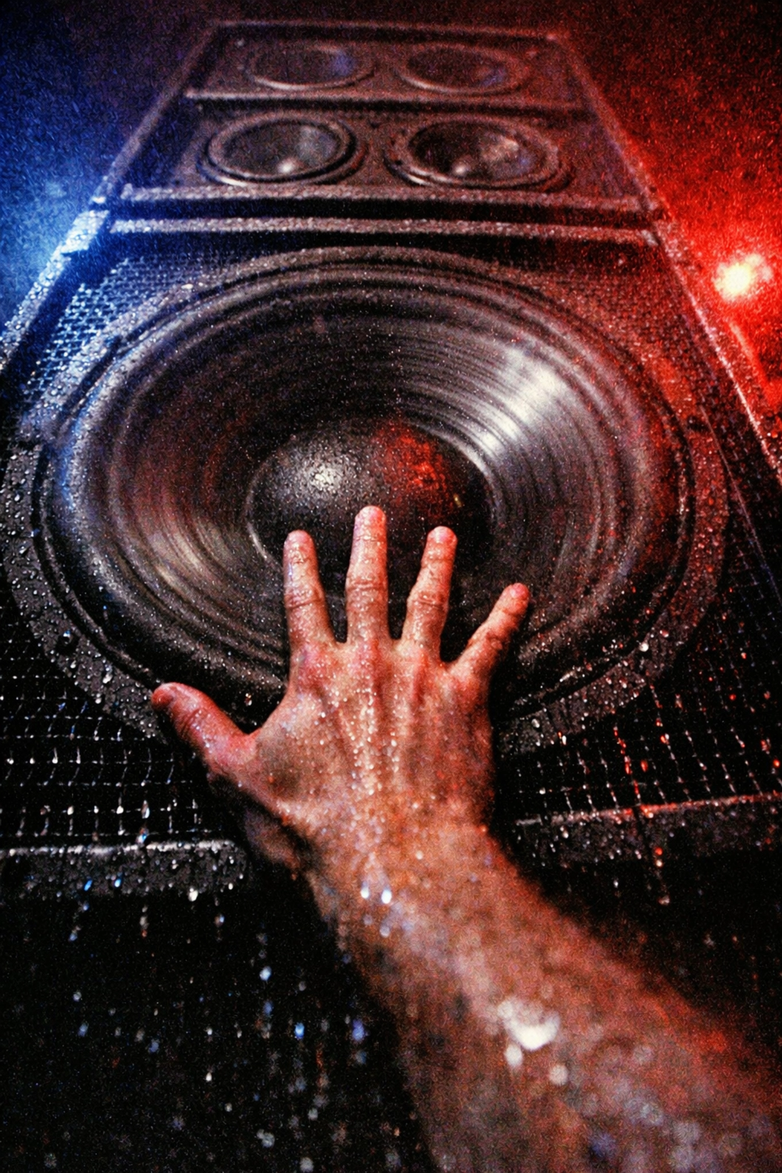 Hand pressed against vibrating club speaker feeling bass frequencies during techno set