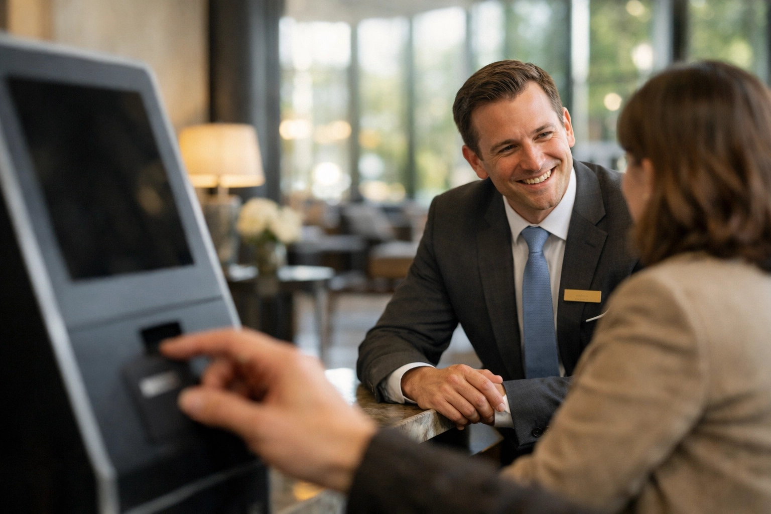 Hotel staff member engaging with a guest, balancing tech efficiency with a personal hospitality touch.