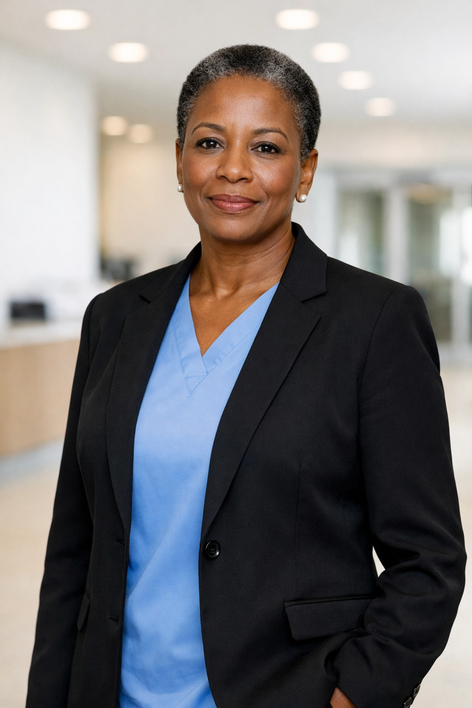 Confident Director of Nursing in a healthcare facility lobby, illustrating the stability of strong clinical leadership.