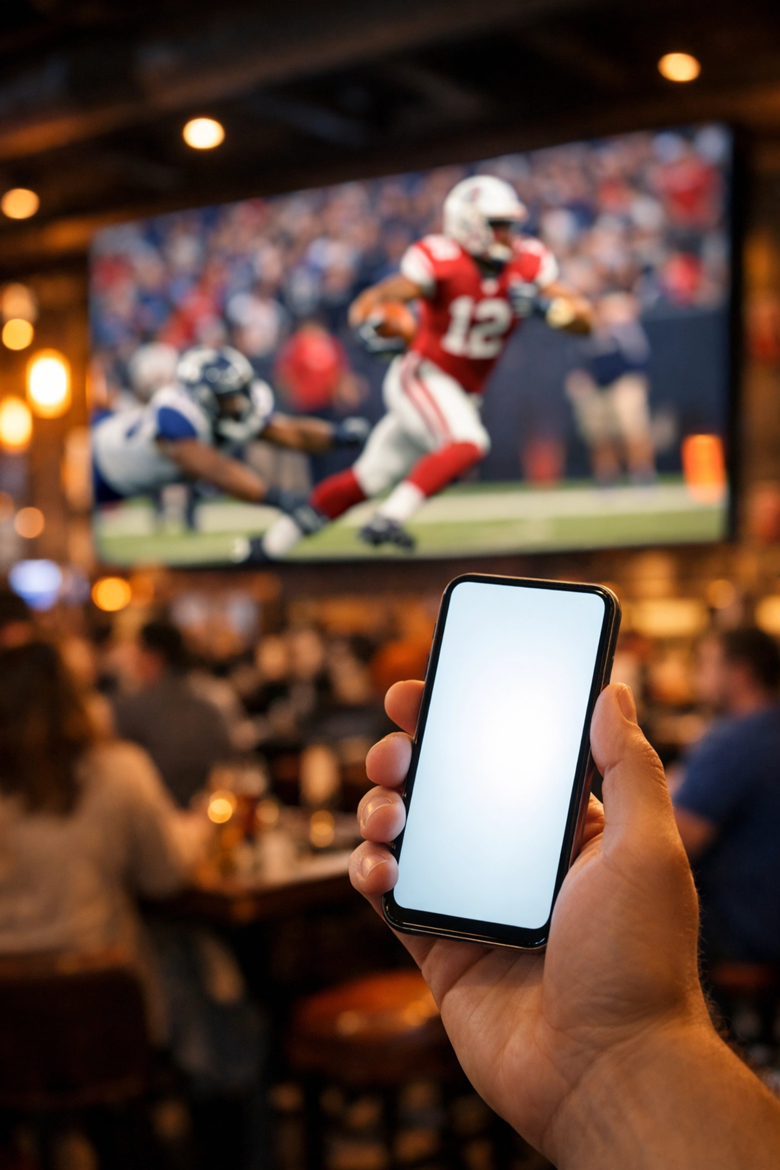 Smartphone user in a sports bar near a digital out-of-home screen showing integrated mobile engagement.