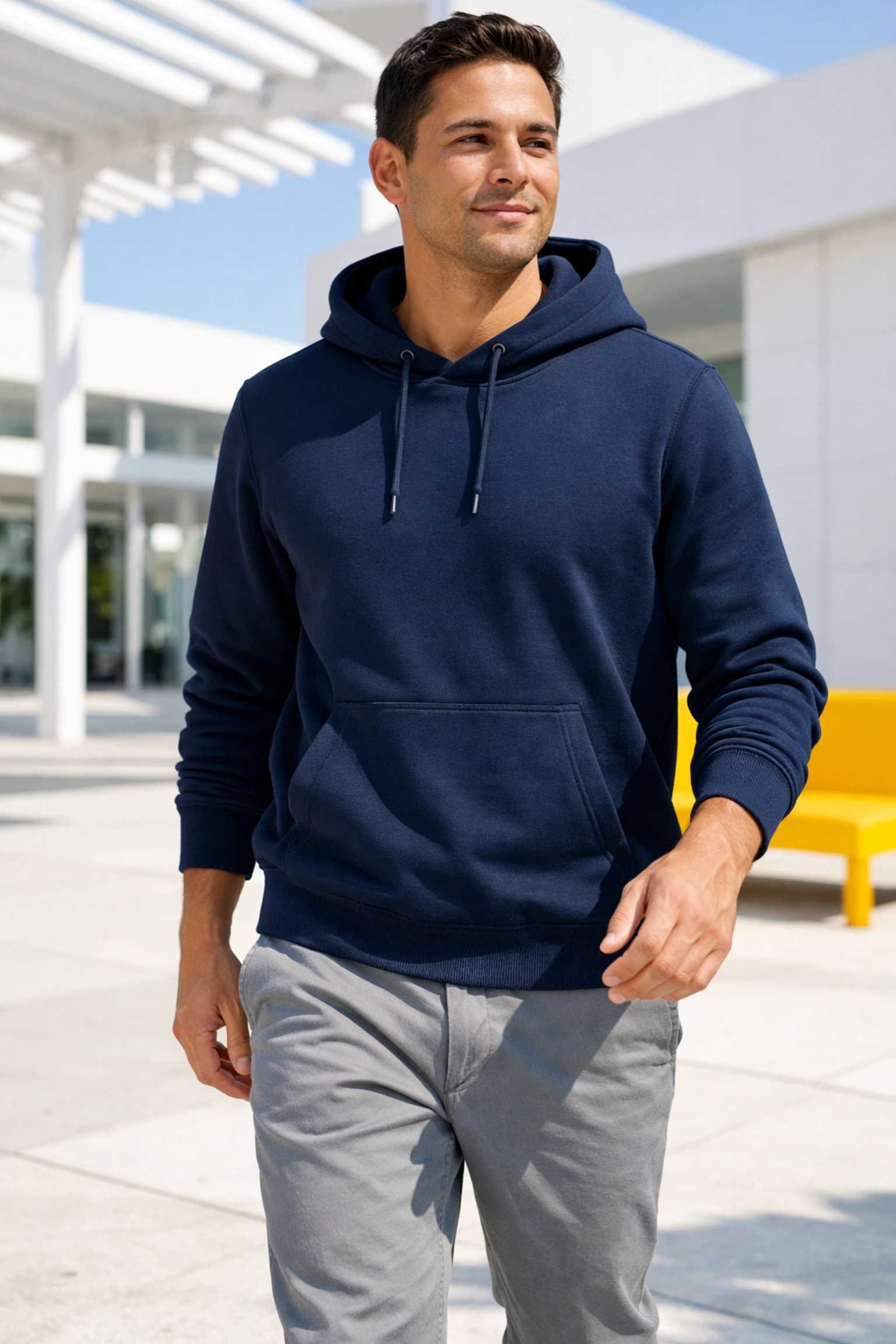 A person wearing a custom navy blue gym hoodie as casual athleisure streetwear in an urban setting.