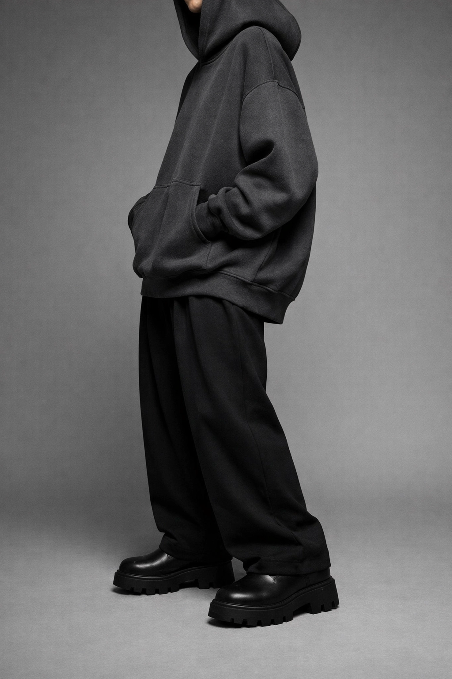 Oversized gray hoodie paired with black wide-leg streetwear pants and chunky boots