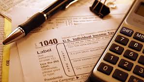 Brick Taxes LLC Essential Tax Tools A 1040 tax form, pen, calculator, and paperclip representing the essential tools Brick Taxes LLC uses to assist clients in preparing and filing accurate tax returns and providing expert tax advisory services.