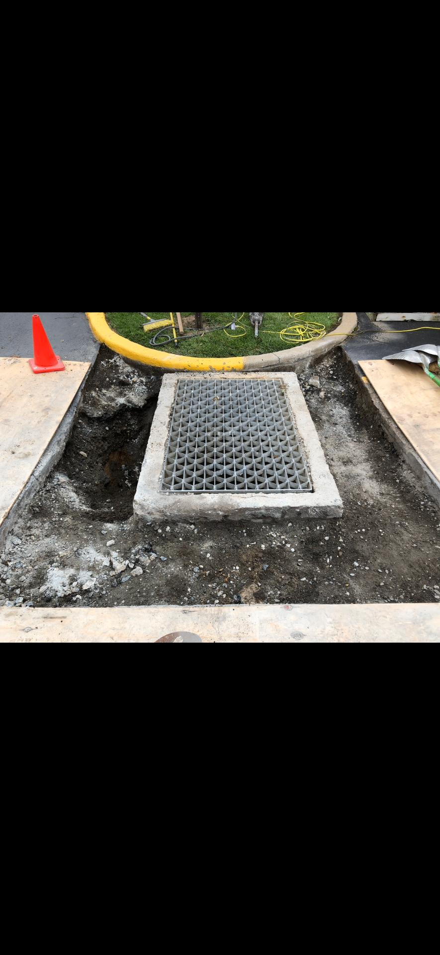 Concrete sidewalk demolition showing precision cutting around infrastructure