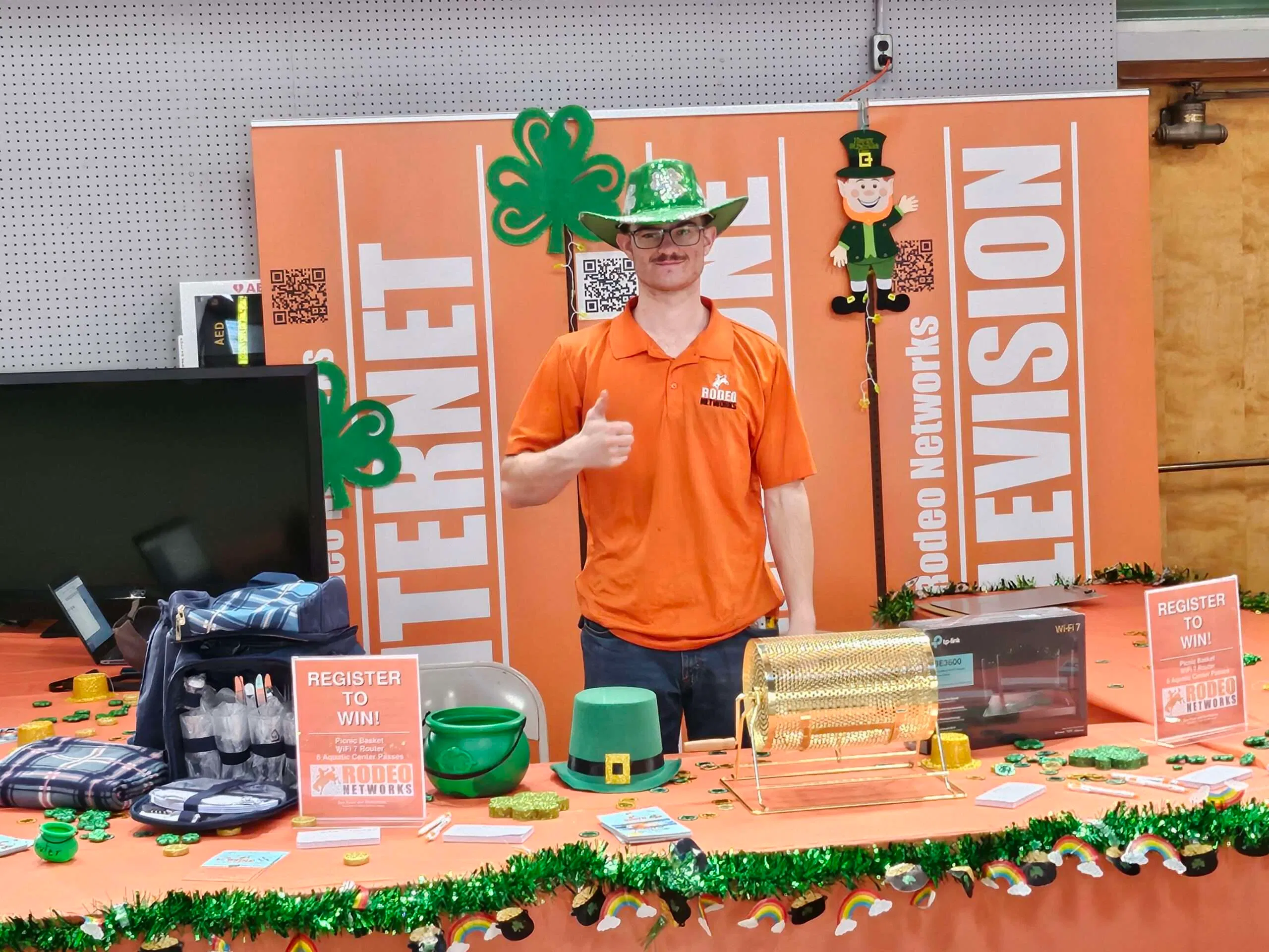 Rodeo Networks staff member at a decorated St. Patrick’s Day themed booth