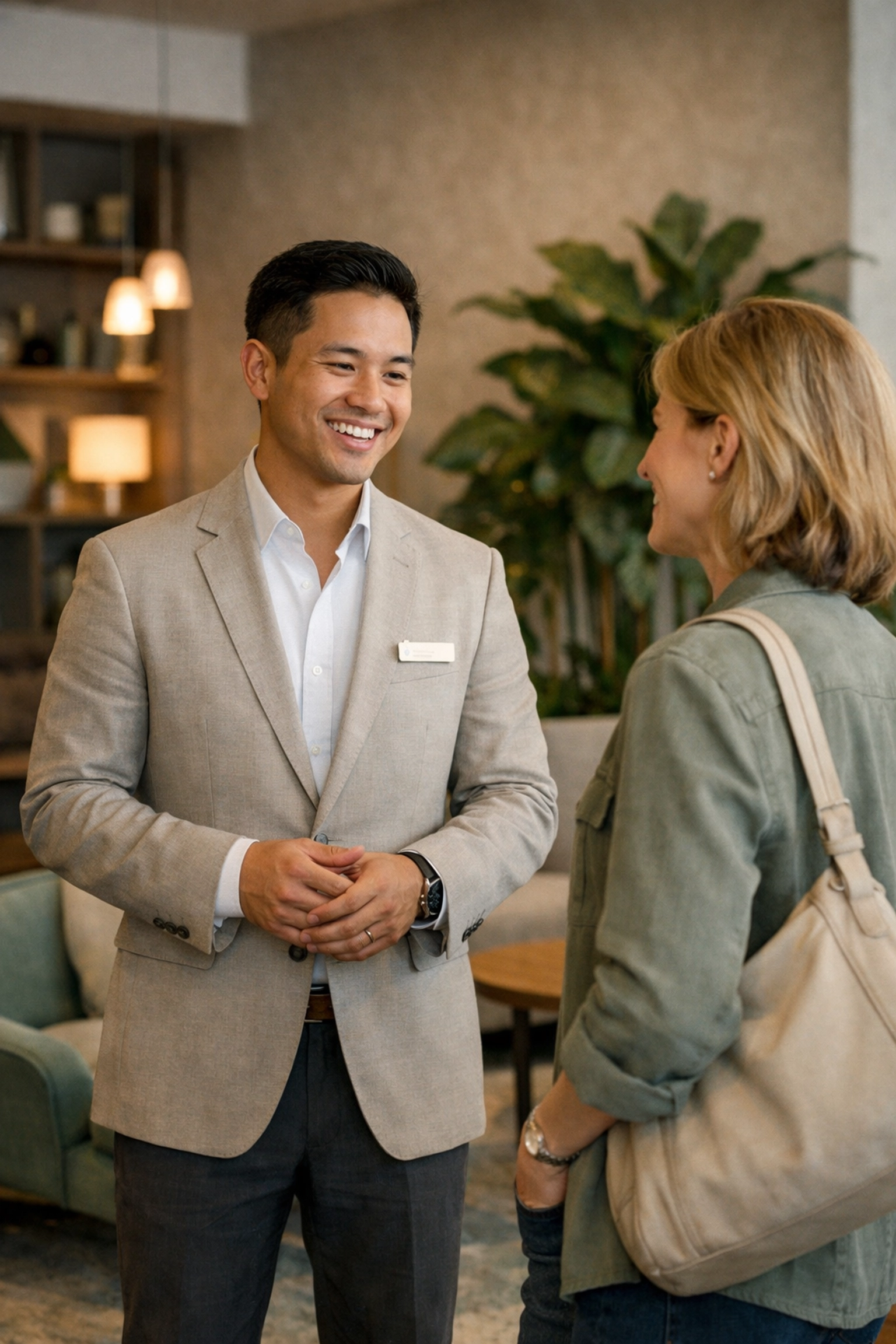 A hotel guest experience host chatting with a traveler in a stylish lounge area.