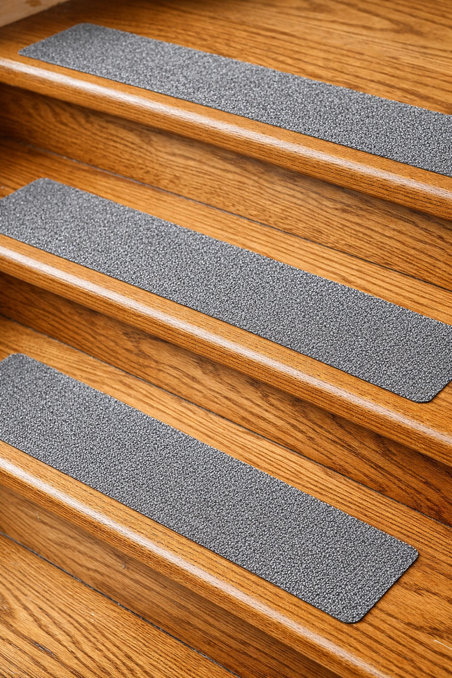 Non-slip adhesive treads installed on wooden stairs for traction and safety