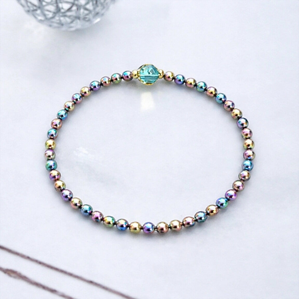 Iridescent metallic round beads showing how color treatments and beadwork elevate mineral materials into expressive art.