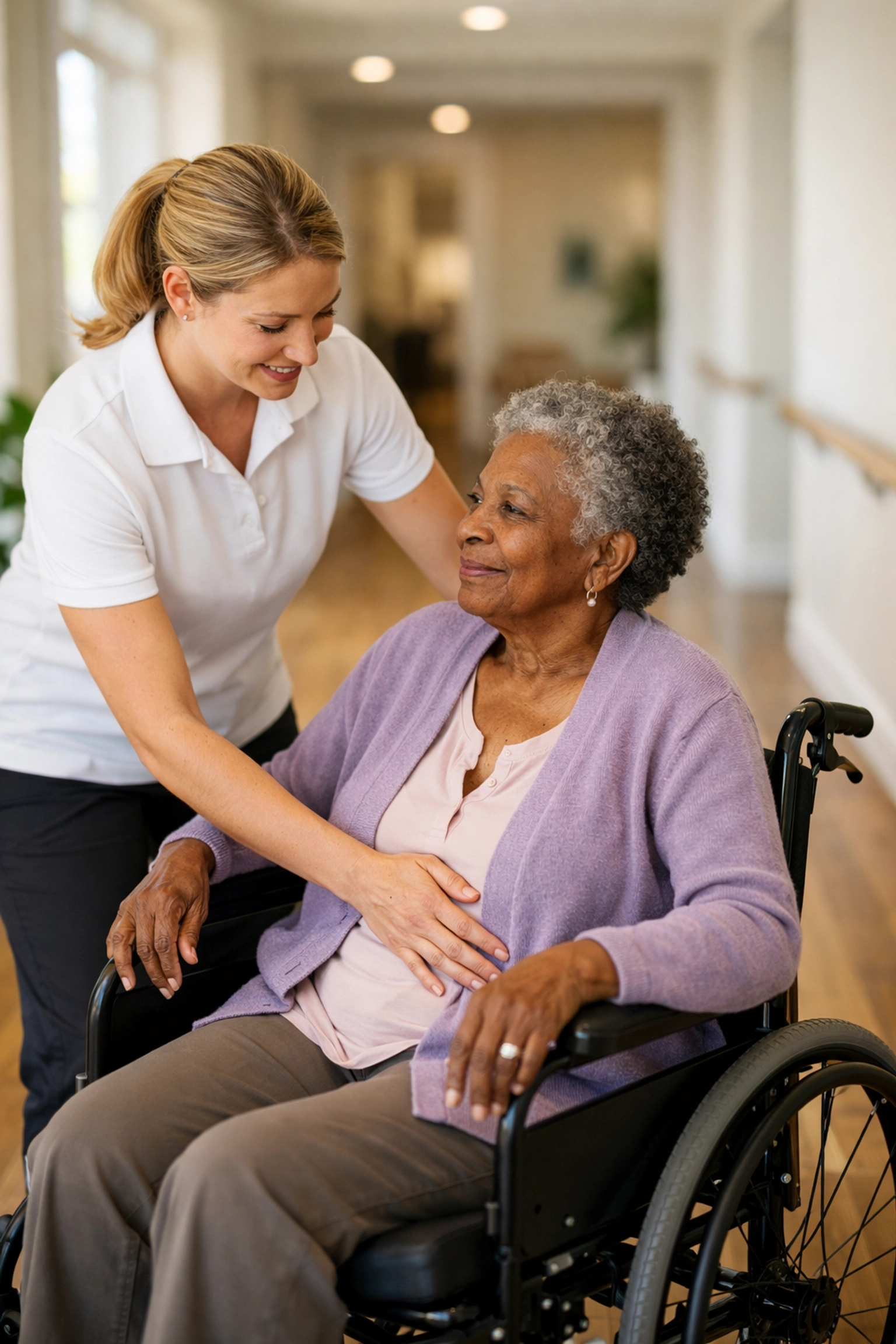 Expert caregiver providing safe wheelchair mobility assistance for a senior in an accessible hallway.