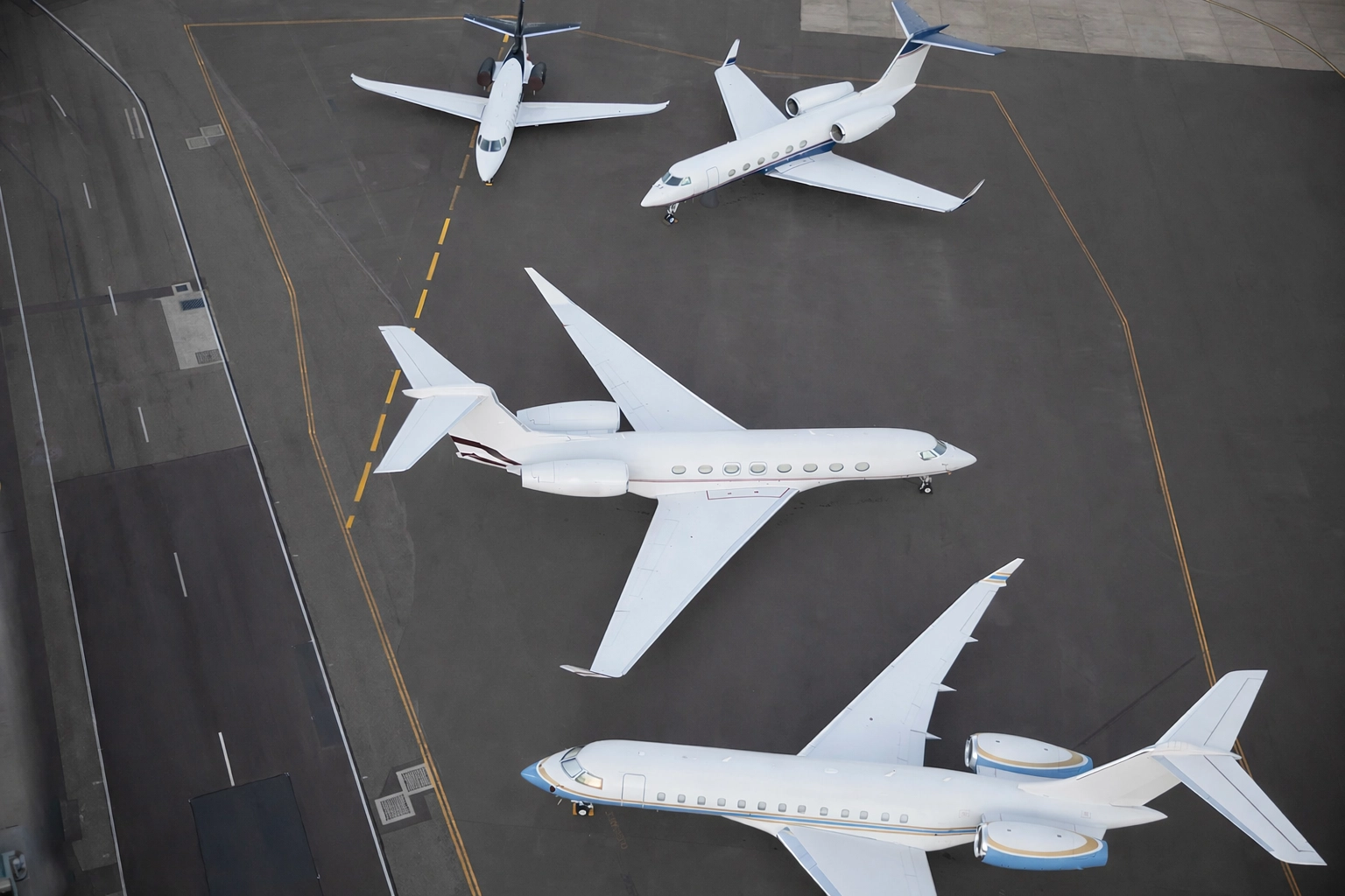 A selection of modern private jets parked on the tarmac