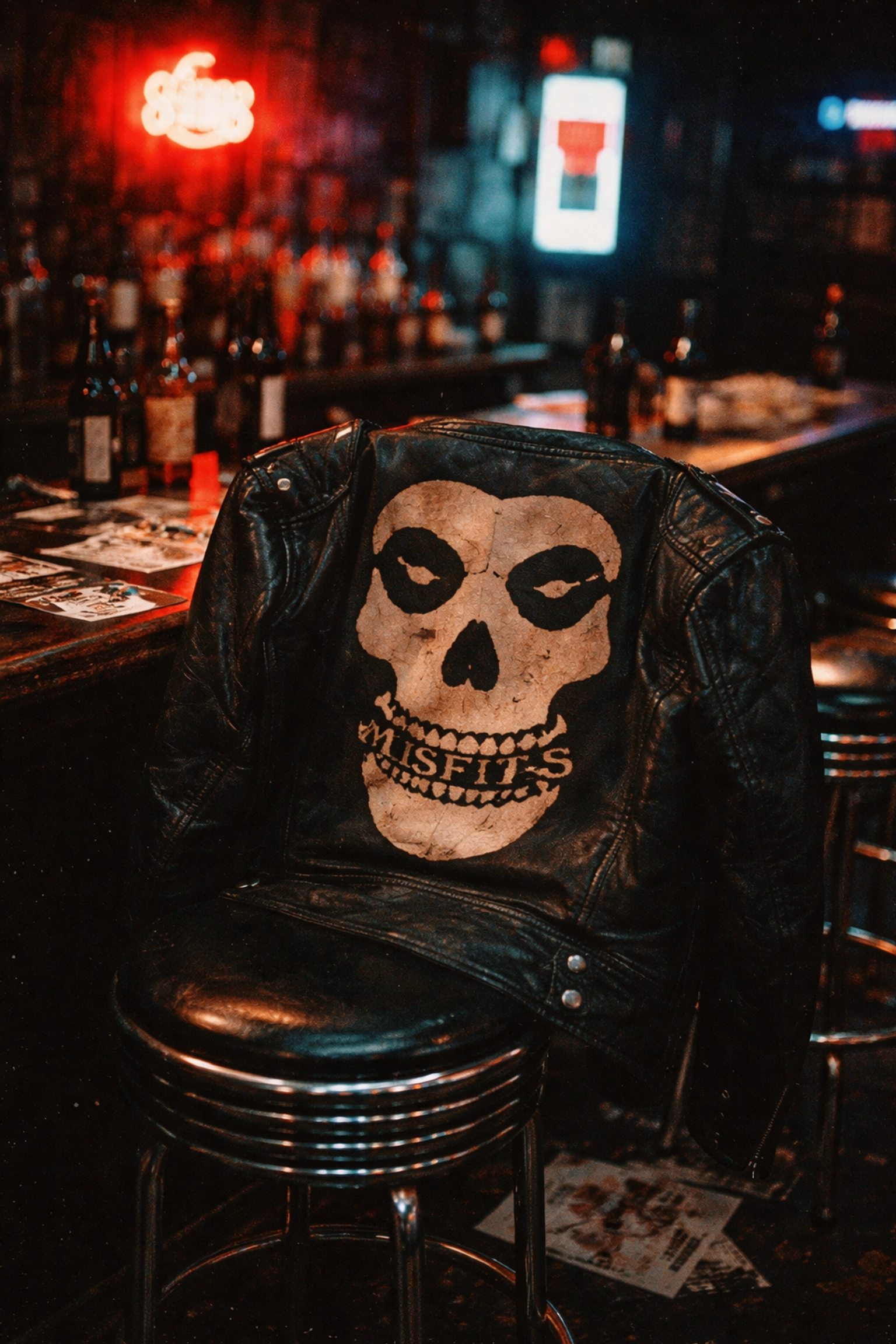 Misfits Crimson Ghost skull logo on a leather jacket in a dive bar, showcasing punk rock merchandise culture