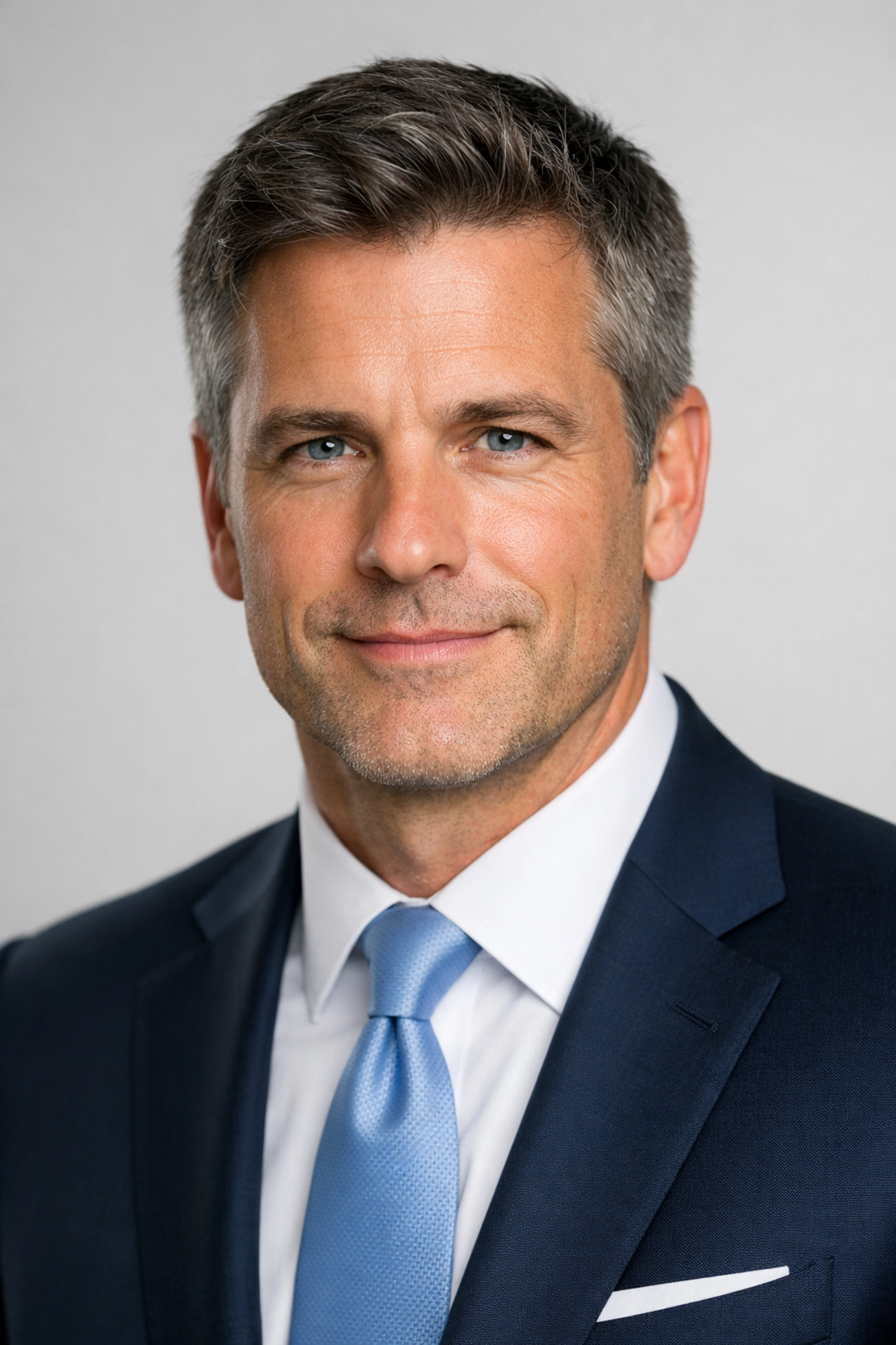Male executive in a navy suit with professional lighting for a high-quality corporate headshot.