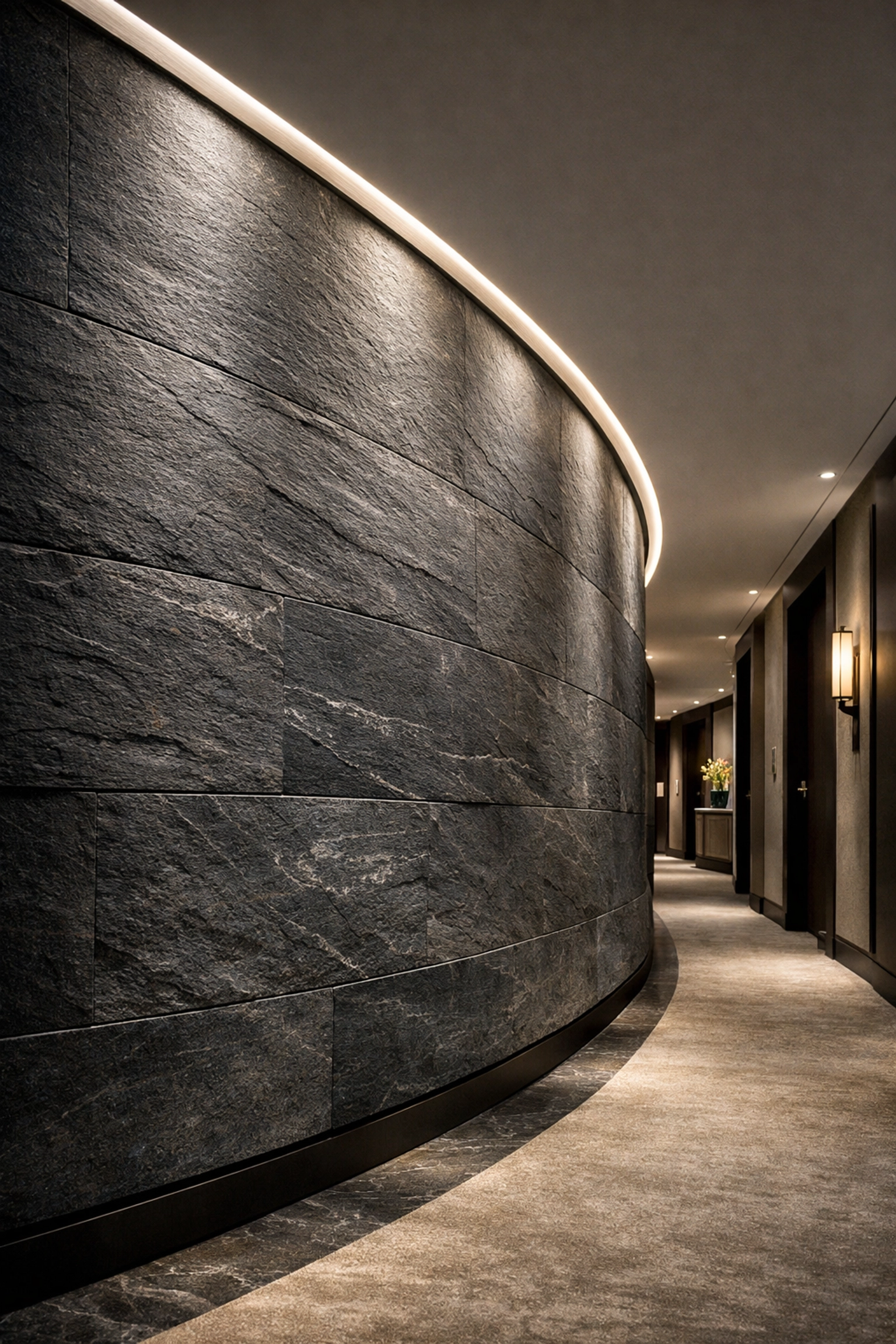Mur de couloir d'hôtel incurvé présentant des panneaux de pierre flexible anthracite avec des détails architecturaux sans couture.