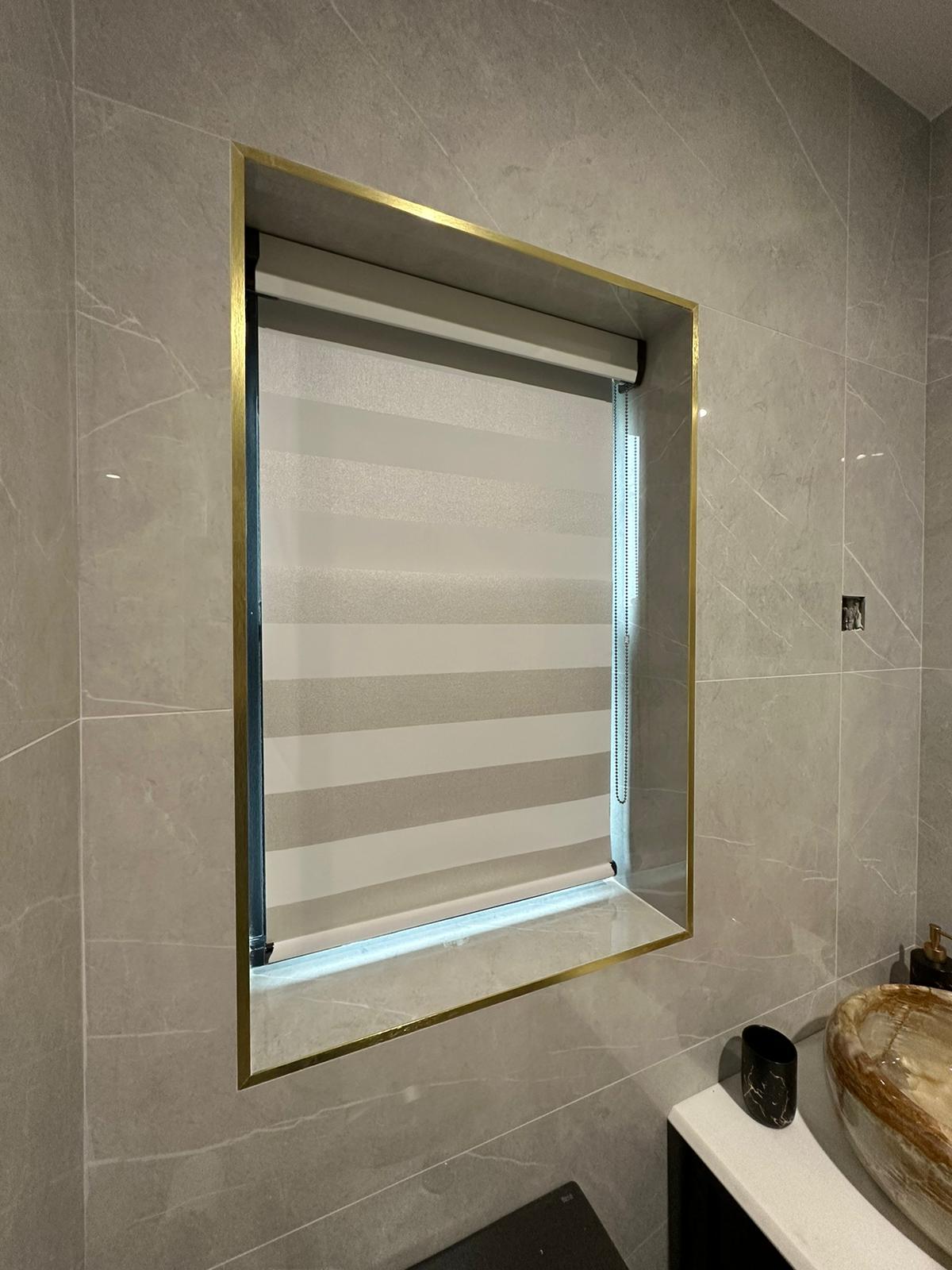 Modern bathroom featuring a custom-installed Fiesta Blinds zebra roller blind with alternating sheer and opaque stripes for adjustable light control and privacy.
