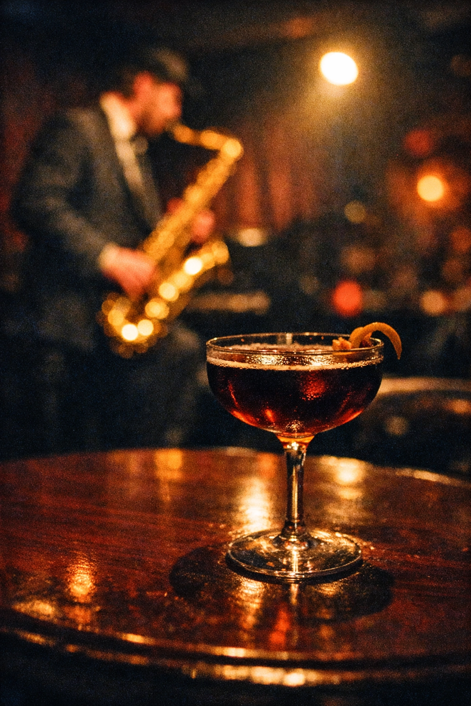 A craft cocktail at a moody Montreal jazz club with a blurred saxophone player in the background.