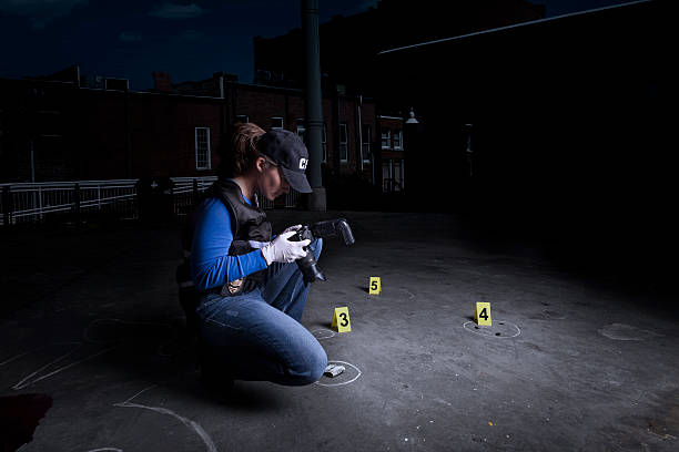 An investigator documenting crime scene evidence at night
