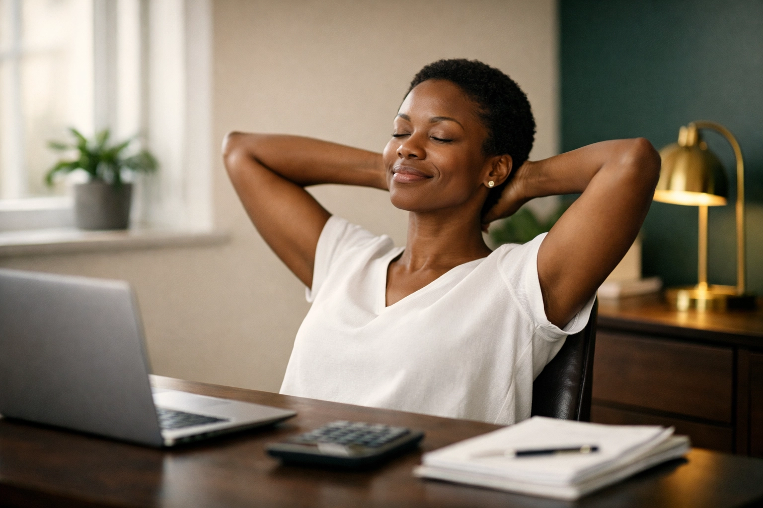 Woman working at organized home office desk calculating simplified home office tax deduction