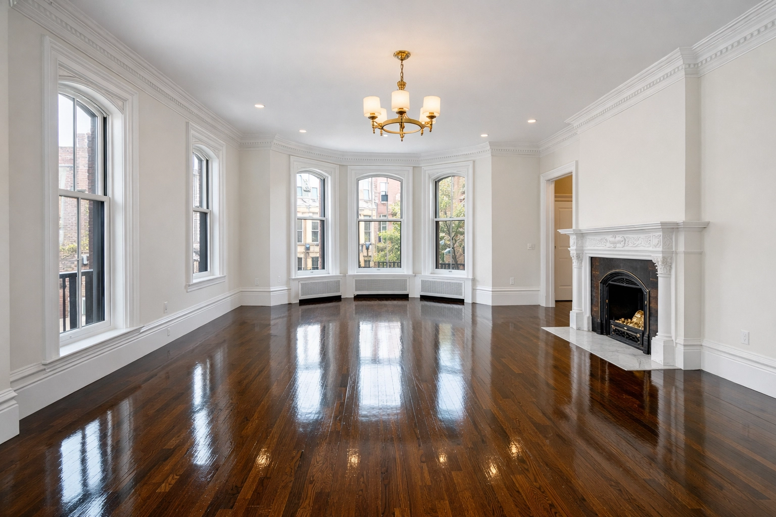 Empty, spotless Boston apartment move-out living room with polished hardwood floors.