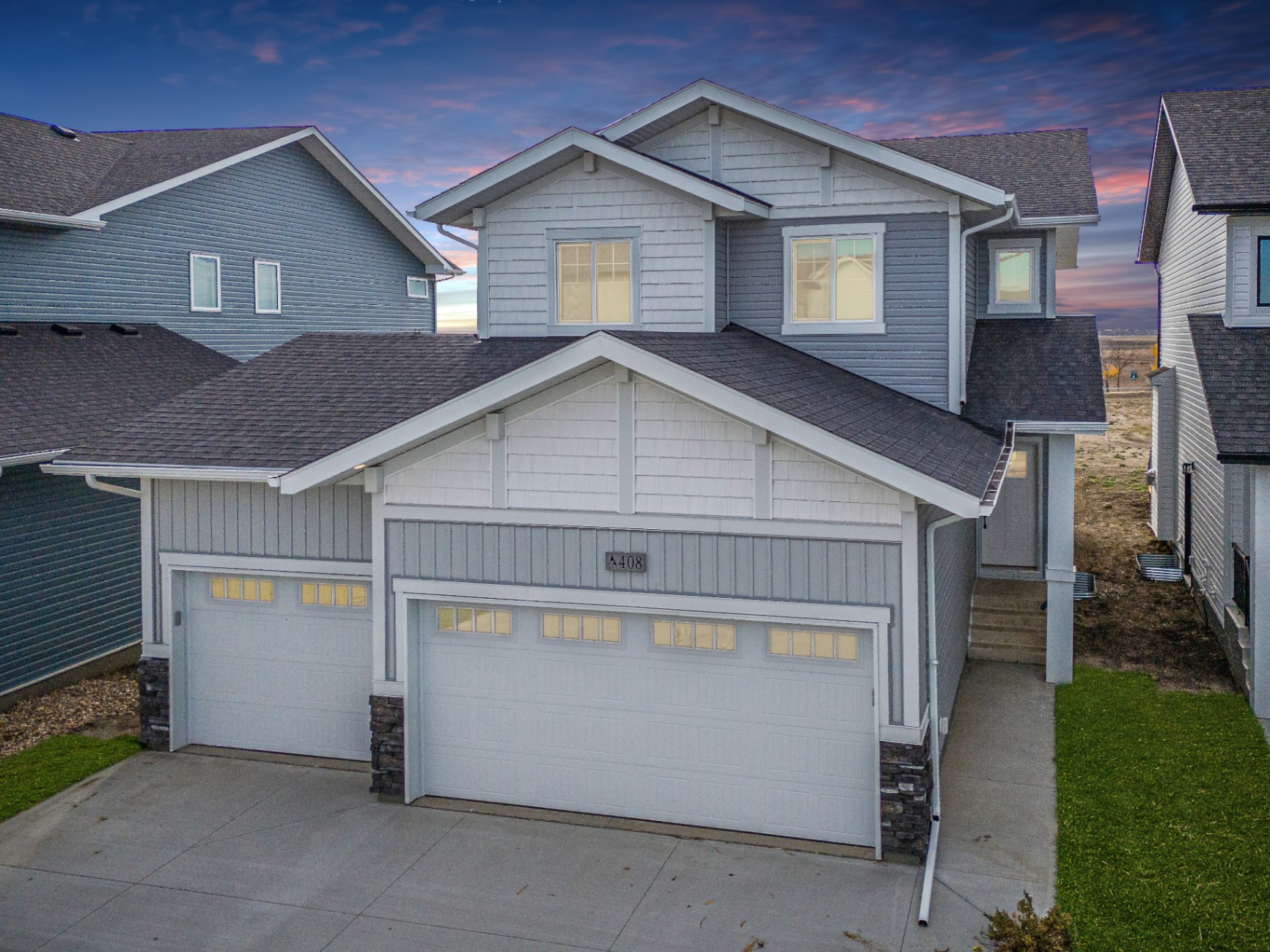 Aerial twilight exterior photo of a modern two-storey home with triple attached garage