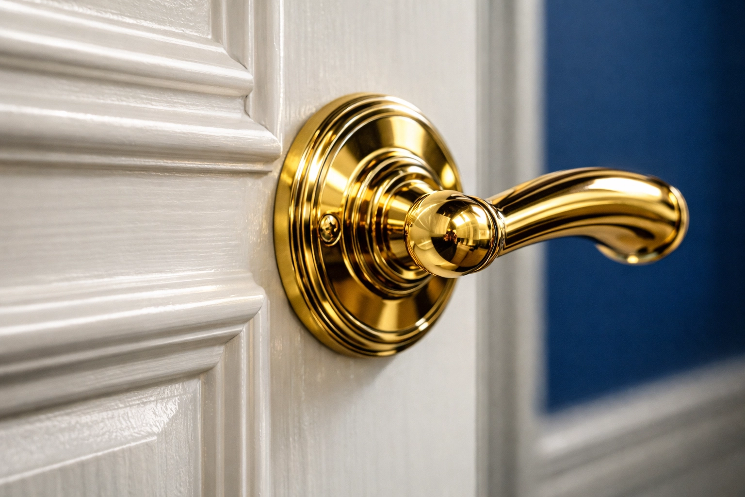 Polished brass door handle and clean white wainscoting in a well-maintained Carlisle luxury estate.