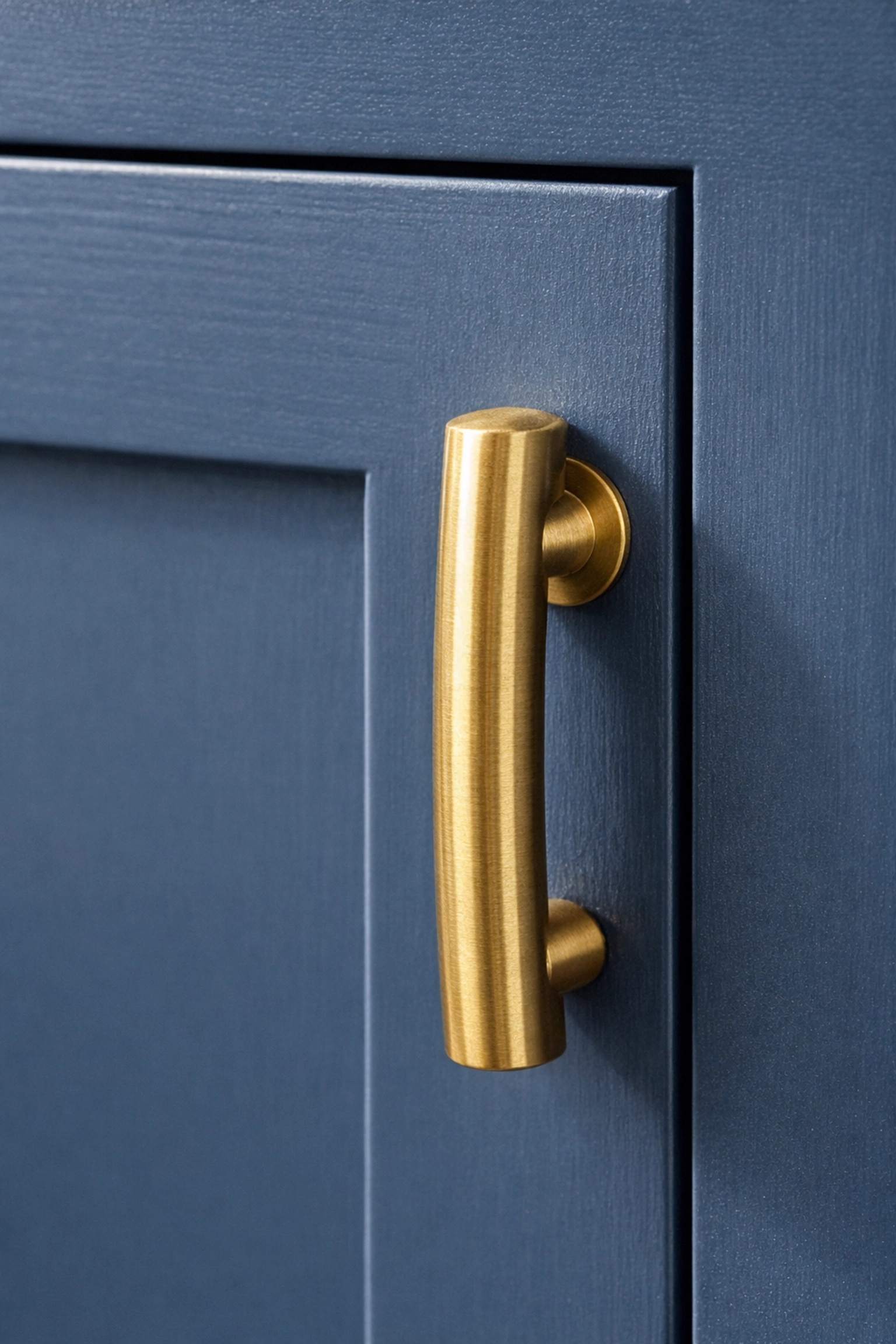Detailed close-up of custom cabinets featuring elegant navy blue inset doors and brass hardware.