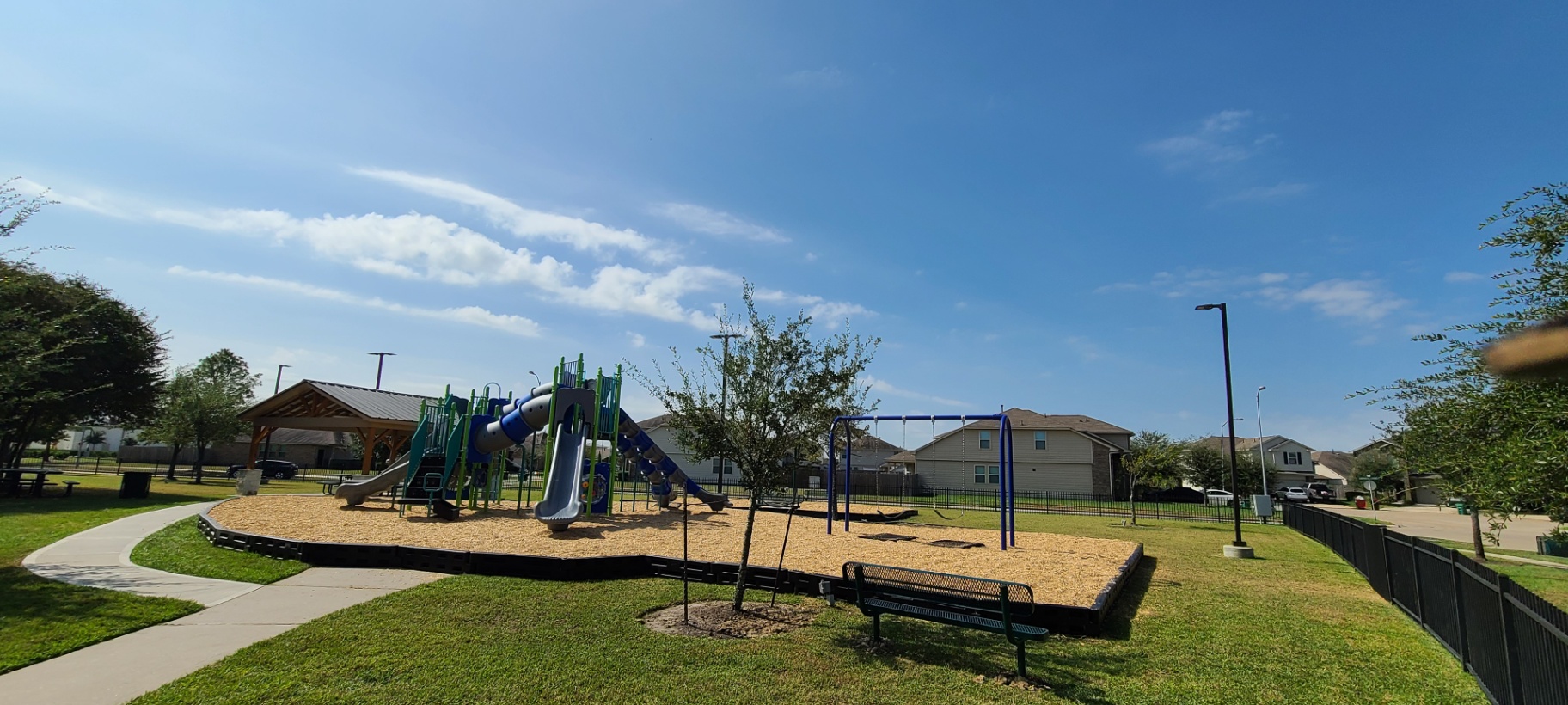 Community playground with poured rubber, pavilion, and seating—amenities that drive foot traffic and local business