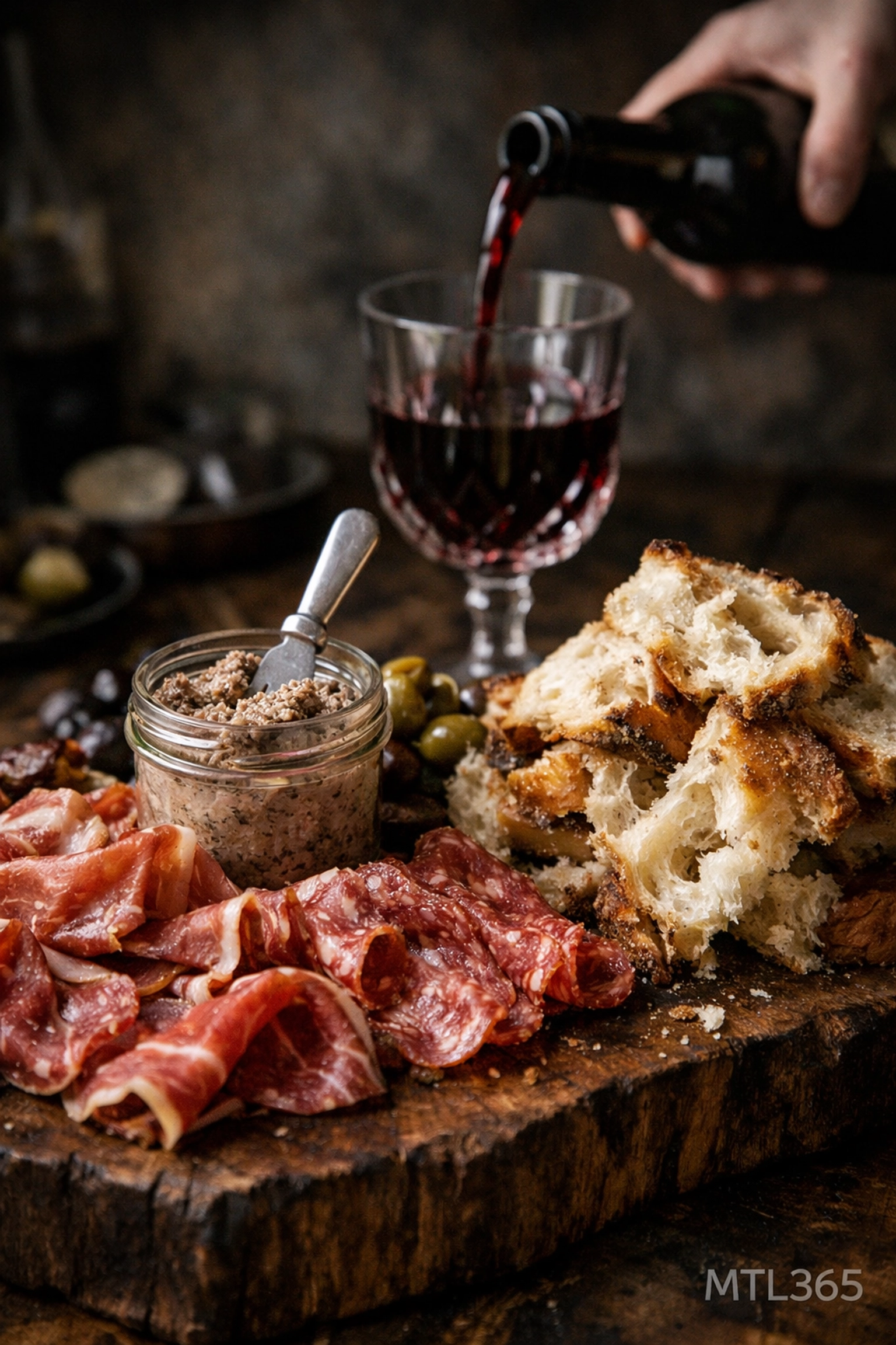 Close-up of a rustic charcuterie board and red wine at Gueuleton, one of the best restaurants in Montreal.