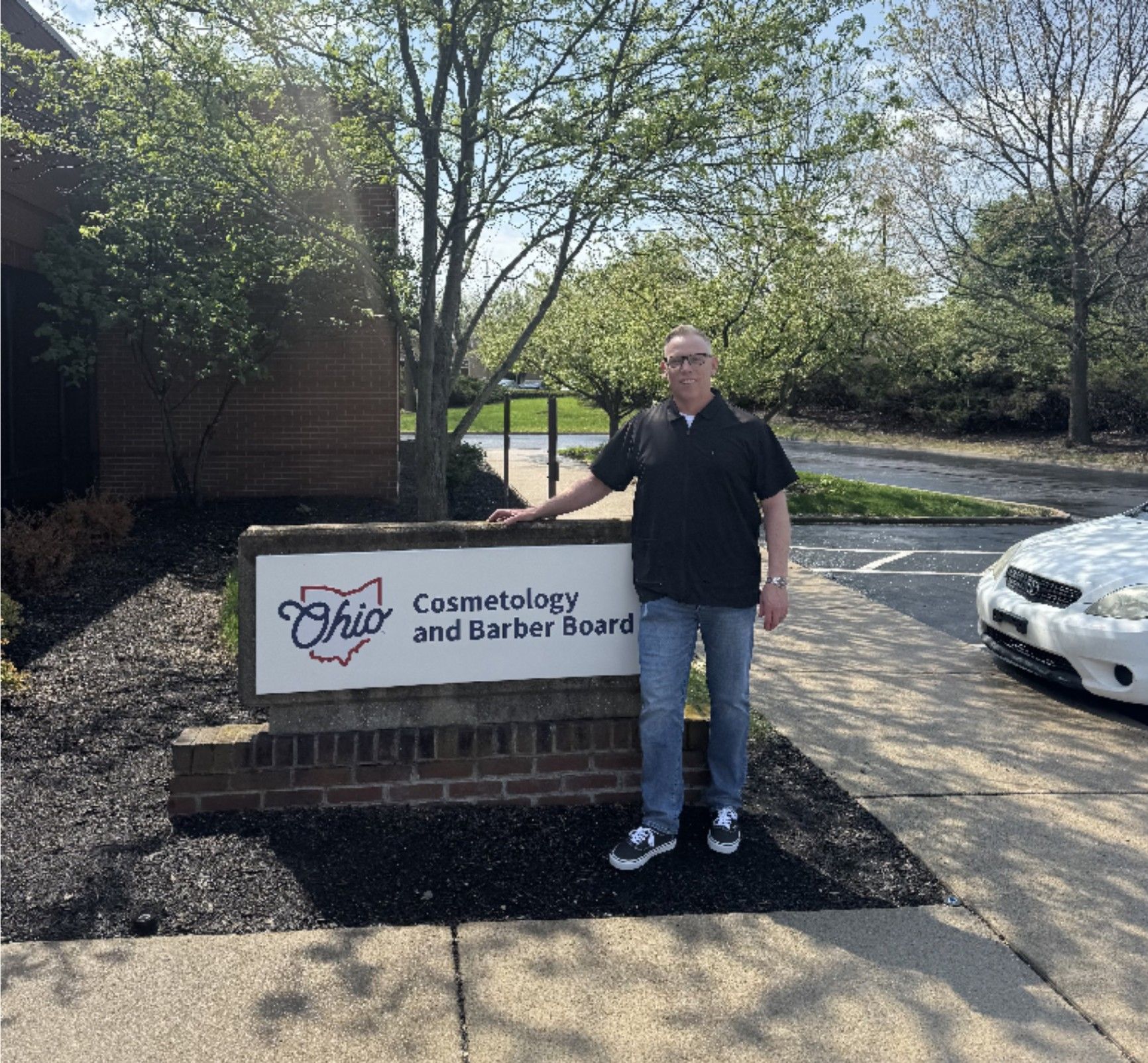 Bobby Thornburg standing in front of the Ohio Cosmetology and Barber Board sign