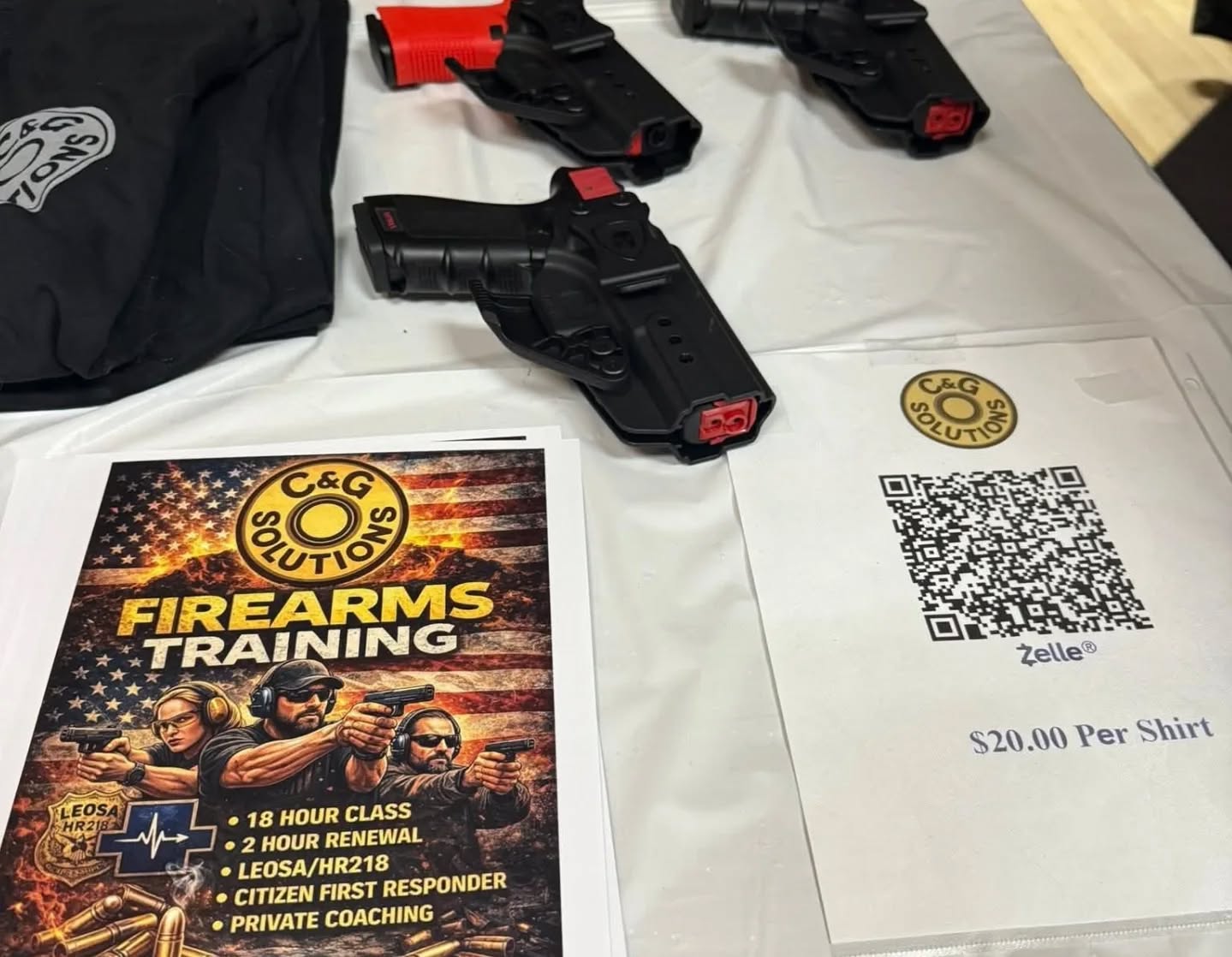 C\&G Solutions table display featuring training materials and non-firing training pistols