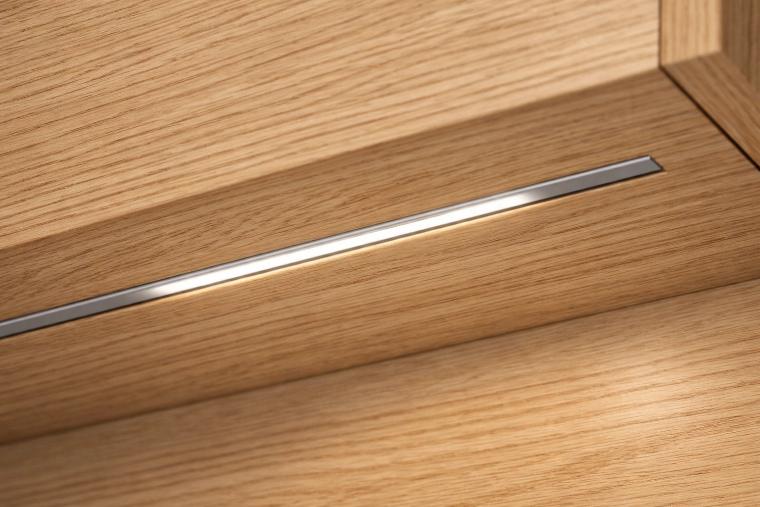 Professional recessed LED lighting strip seamlessly integrated into custom oak kitchen cabinetry.