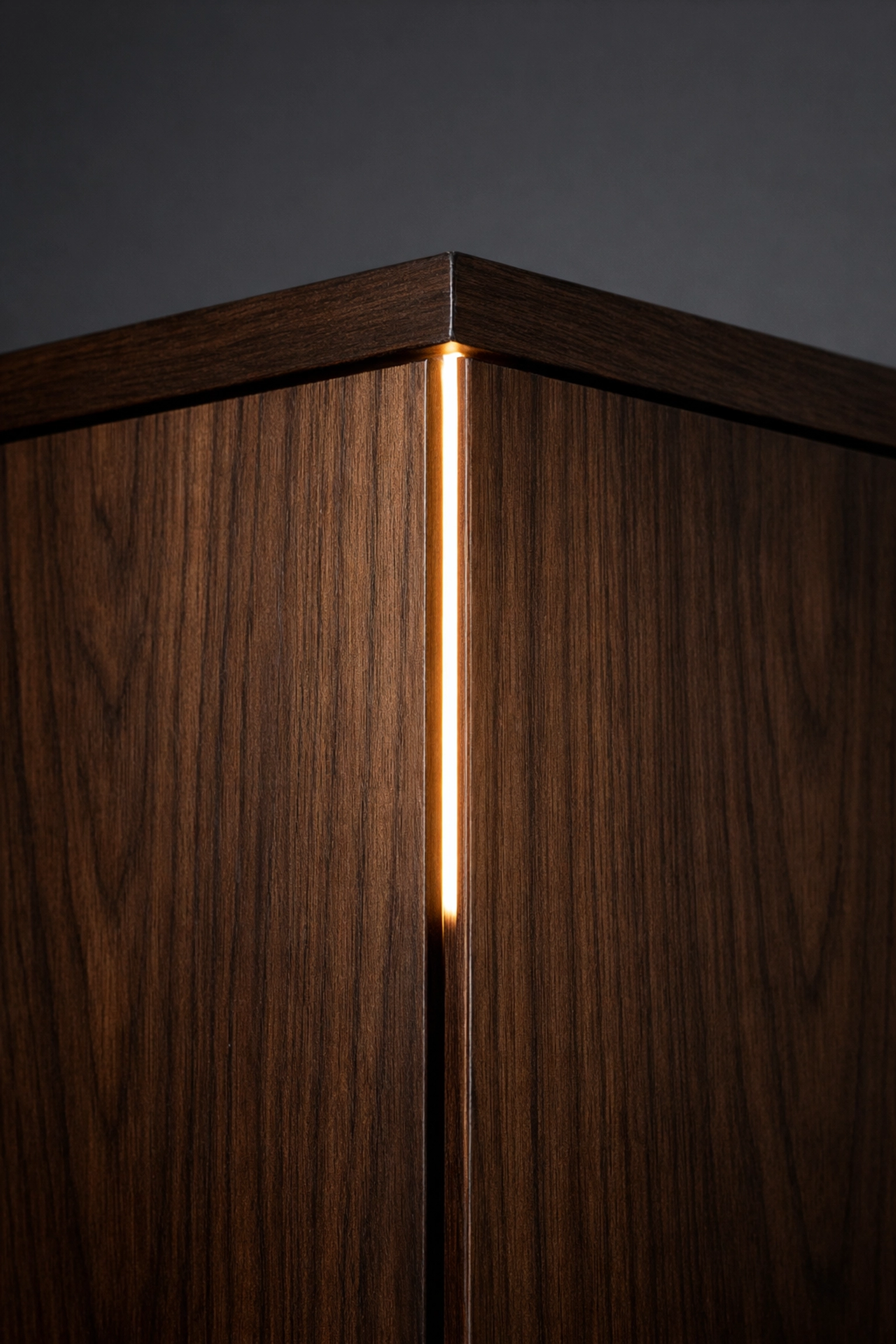 Recessed linear LED lighting integrated into a dark walnut custom cabinet corner.