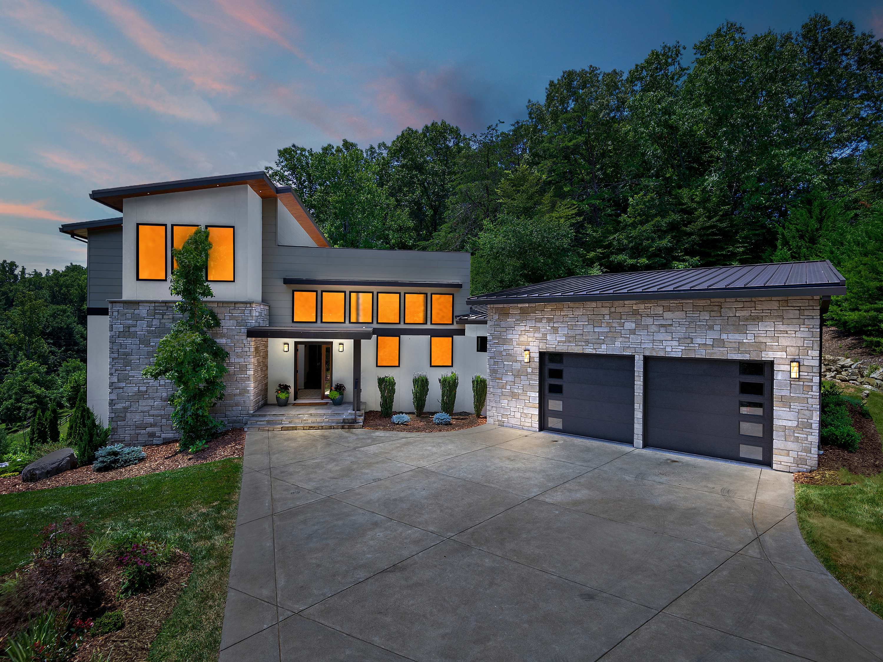 A sunset view of a luxury modern mountain retreat in Western North Carolina managed by PMI Blue Ridge.