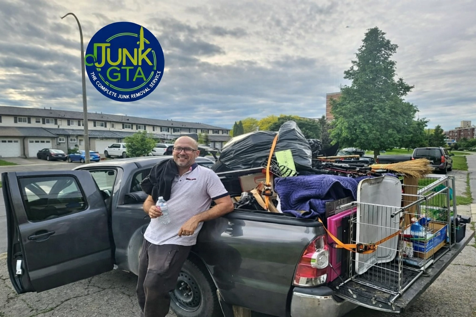 Roman, owner of Junk GTA, standing by his truck loaded with junk for removal in a residential neighborhood