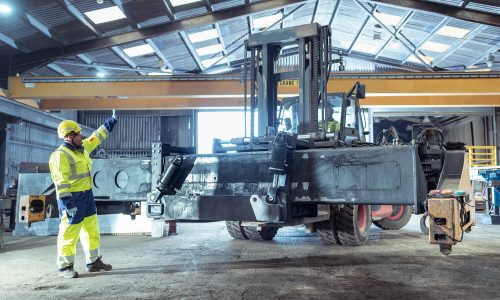 Engineer Directing Forklift Repair in Workshop