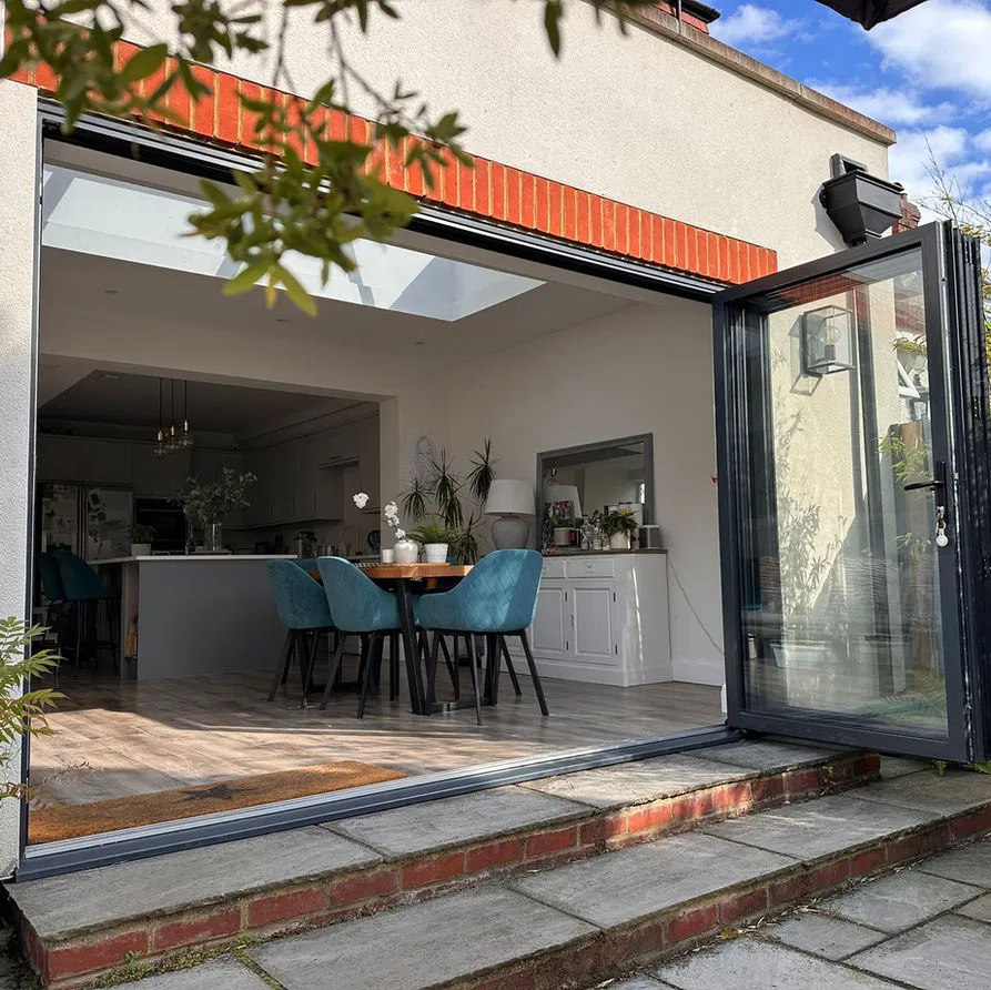 Open-plan kitchen and dining area with large skylight and full-width bi-fold doors, highlighting integrated architectural and structural engineering