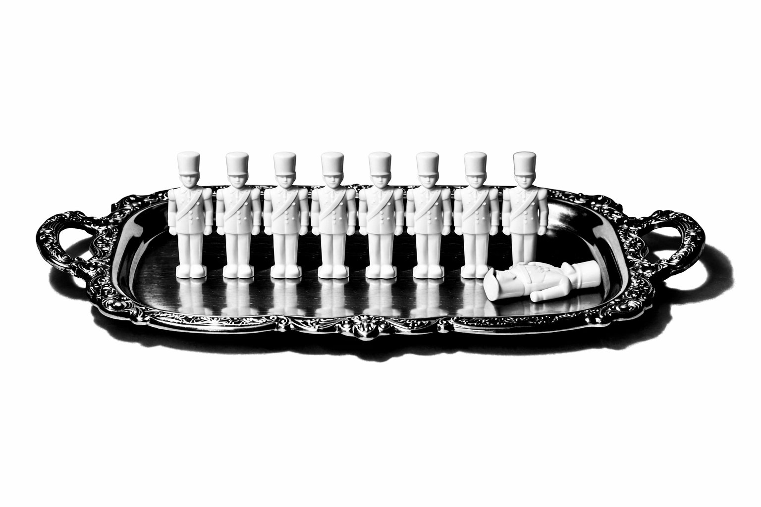 Ten porcelain soldier figurines on a silver tray, representing the mystery in Agatha Christie's classic novel.