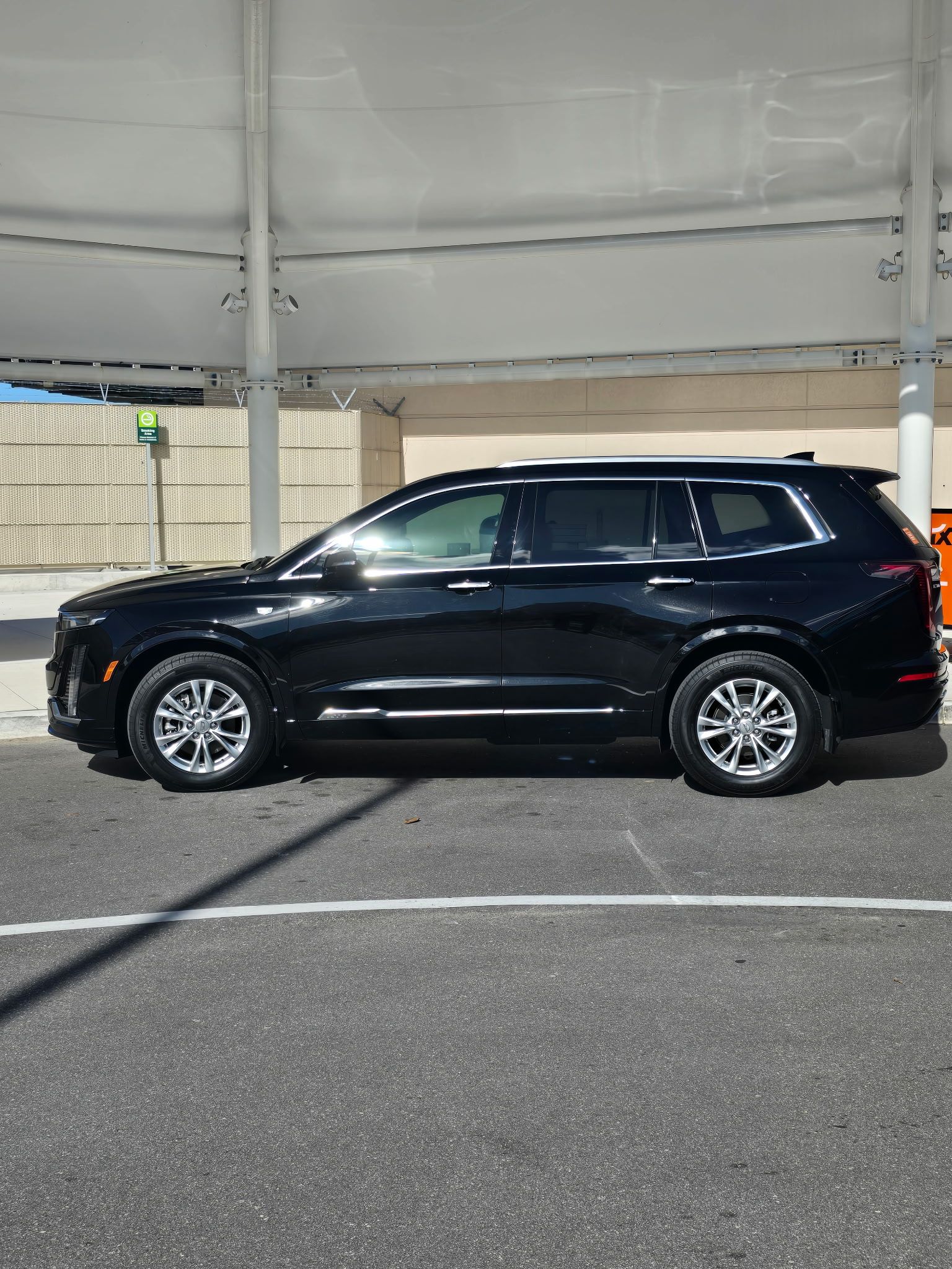 Professional Cadillac XT6 curbside at the airport