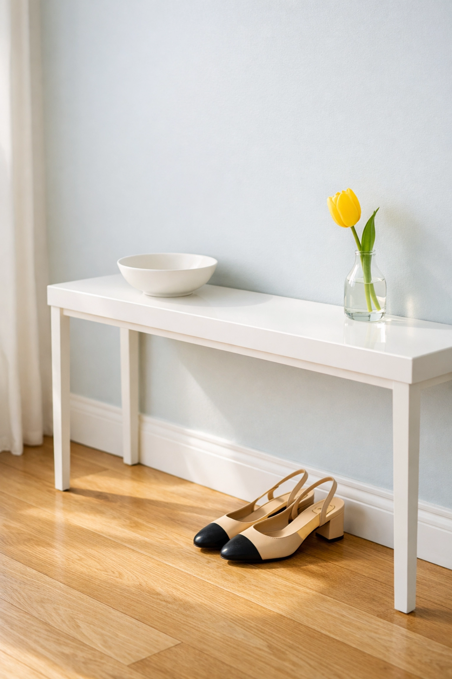 Minimalist entryway with a tidy white console table and organized hardwood floors.