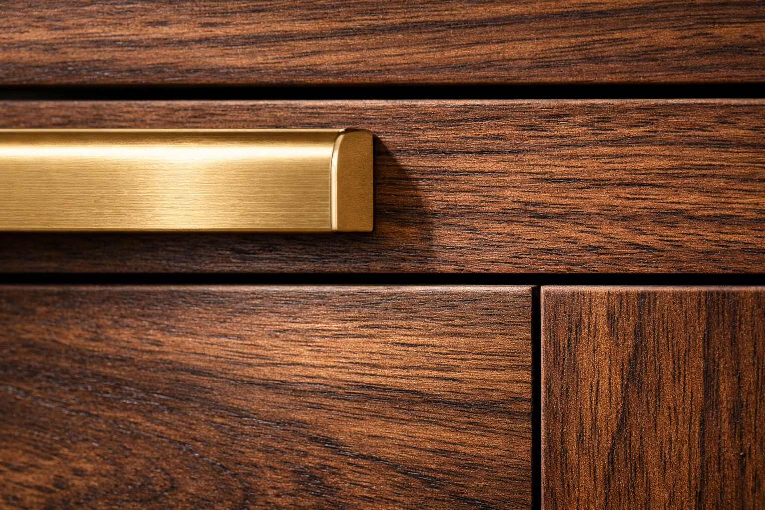 Brushed brass hardware on a dark-stained wood drawer showcasing custom cabinet details.