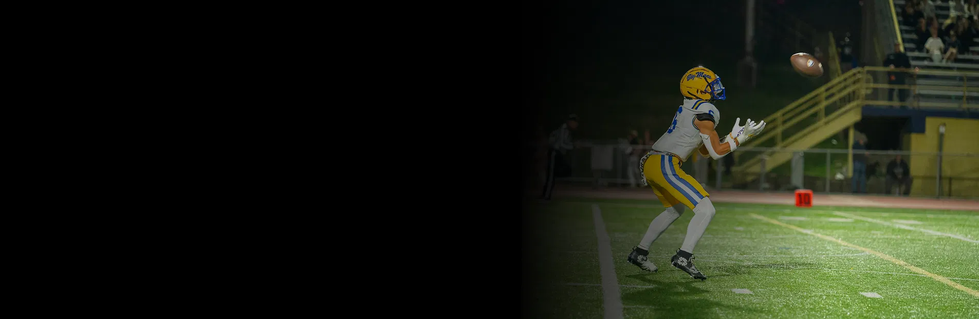 college-football-player-blue-yellow-spotlight-catch.webp