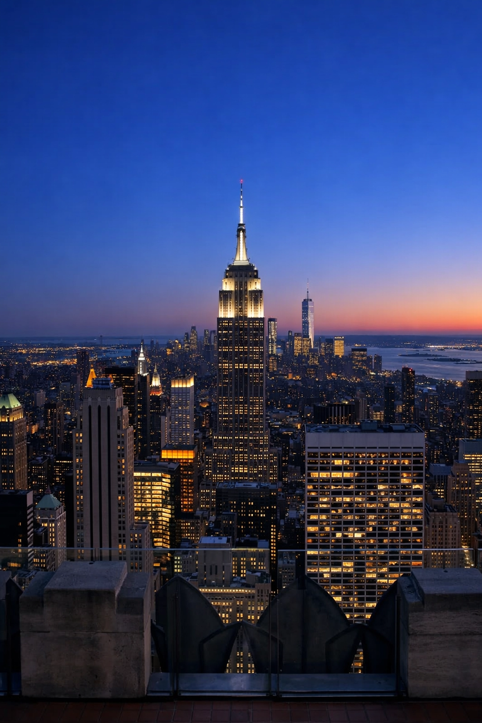 View of the Empire State Building from Top of the Rock, a top New York City photography location at twilight.