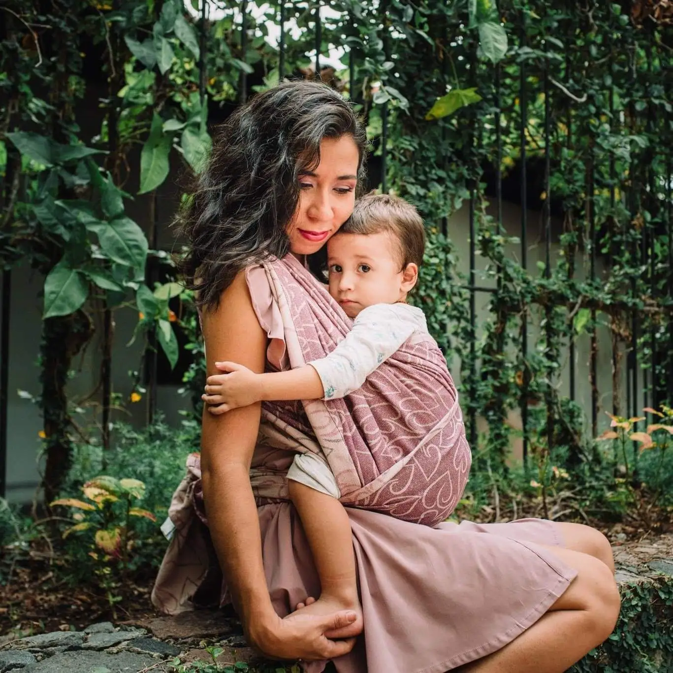 Aura porteando a su hijo afuera, mostrando el vínculo y el acompañamiento en la crianza.