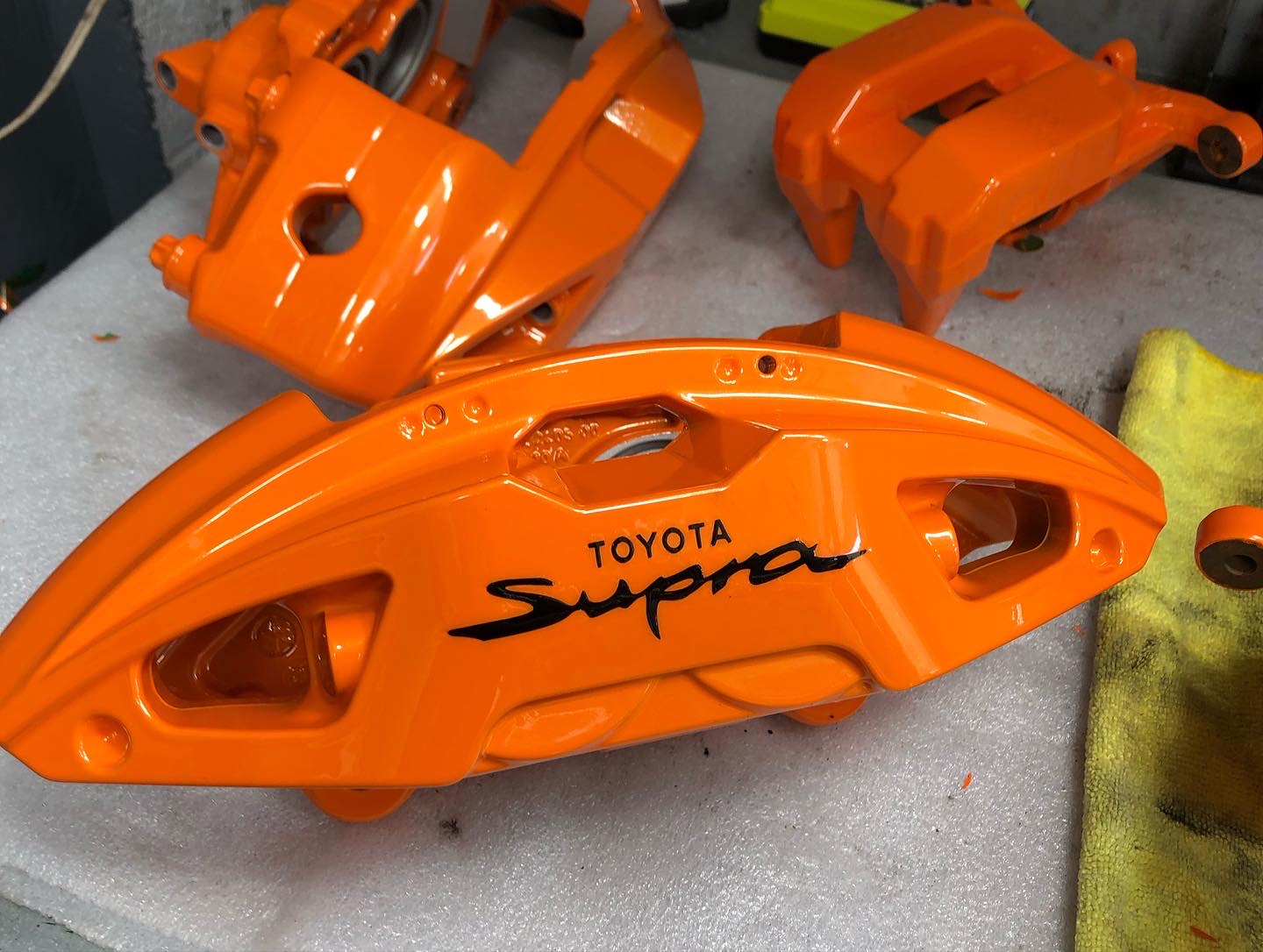 High-gloss orange powder-coated brake calipers showcasing a durable and vibrant custom finish by California Calipers and Powder Coat It.