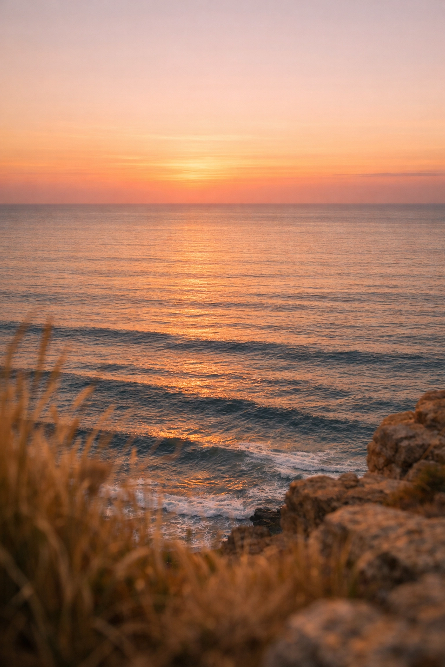 A serene coastal sunset over the ocean, representing a peaceful location for scattering ashes at sea.