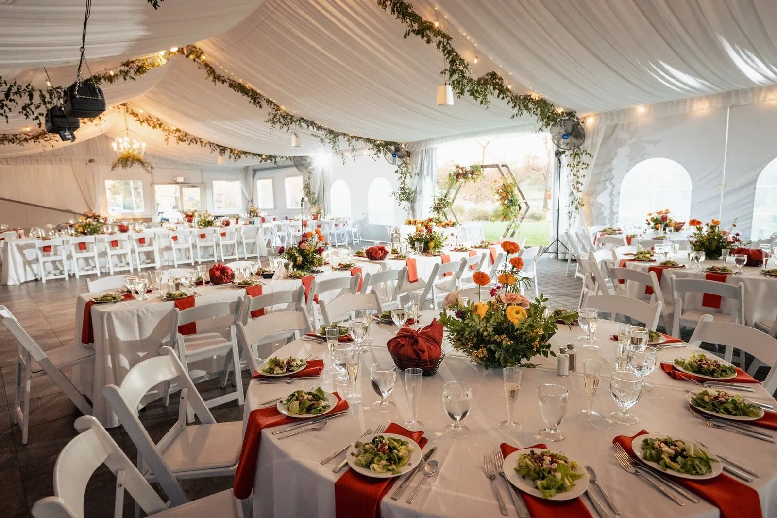 Close-up of elegant autumn table settings with orange napkins and sparkling glassware